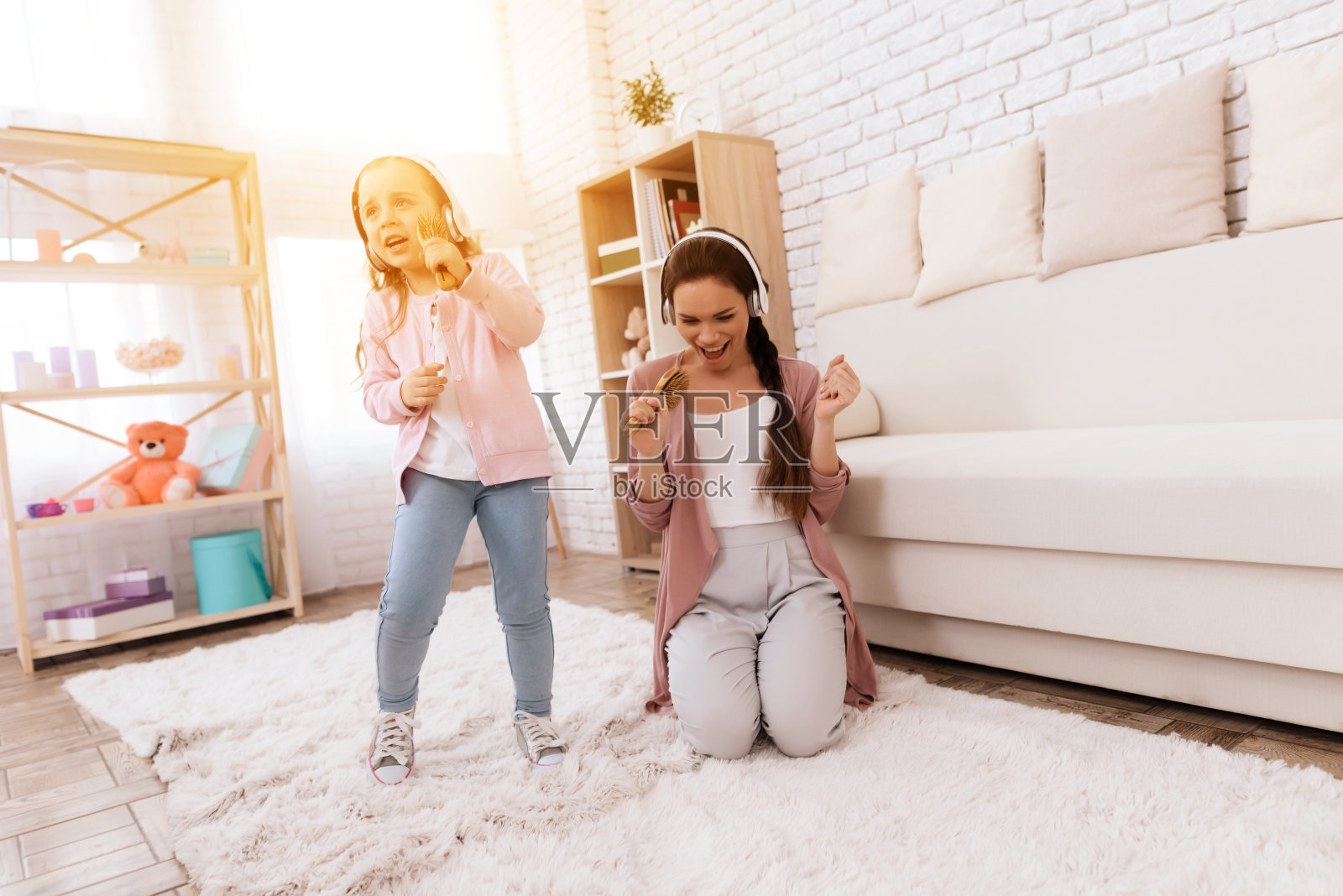 妈妈和女儿在家唱歌。照片摄影图片
