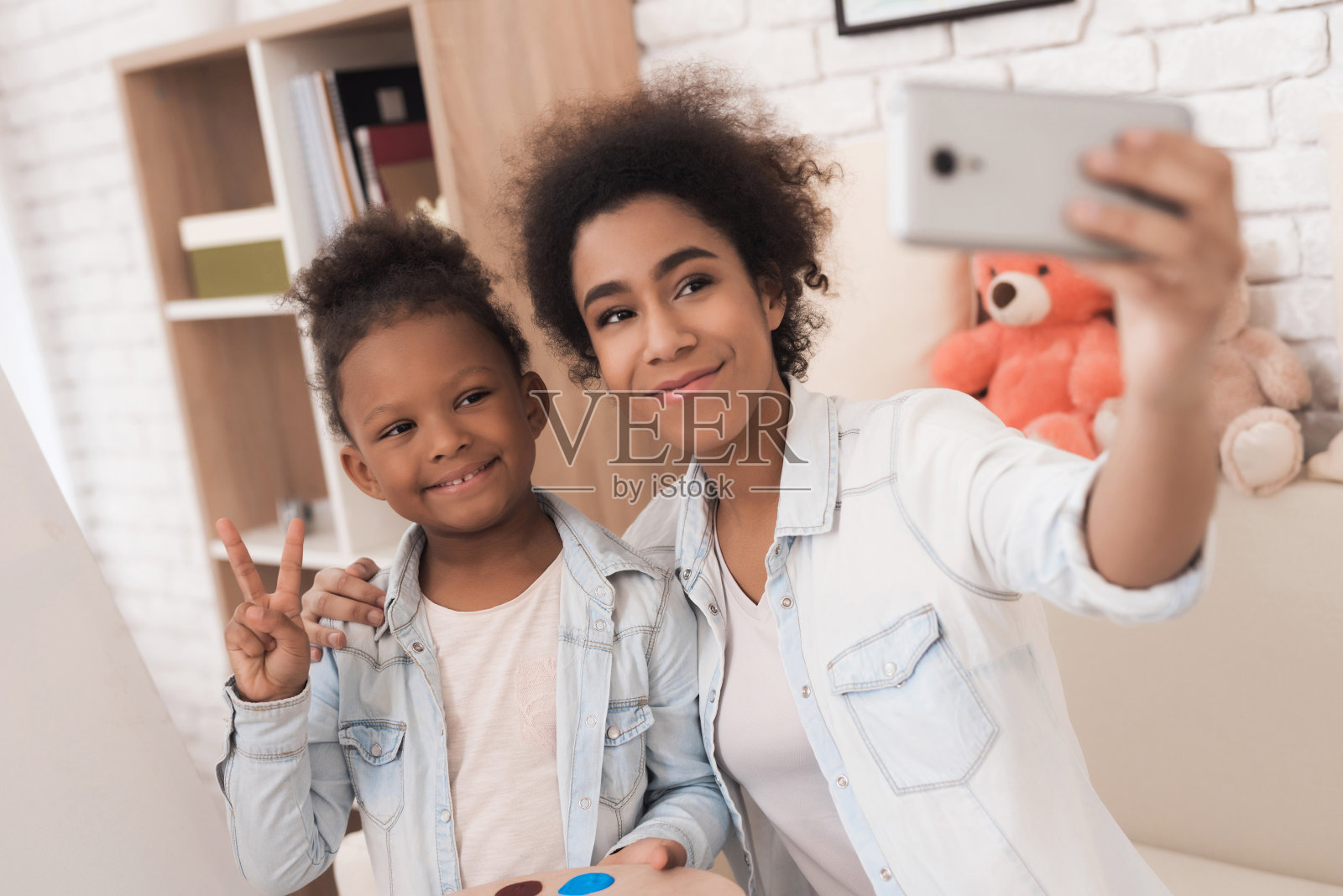 年轻女子和小女孩在手握调色板自拍。照片摄影图片