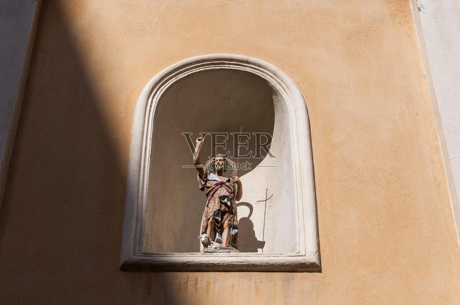 科西嘉:在阿雅克肖最古老的宗教建筑——圣约翰浸礼会教堂外墙壁龛上的圣约翰浸礼会雕像照片摄影图片