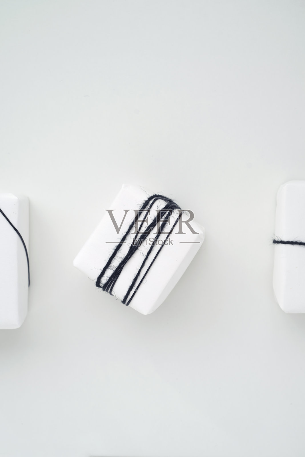 地区圣诞元素。最小包装的礼物。白纸和黑丝带。照片摄影图片