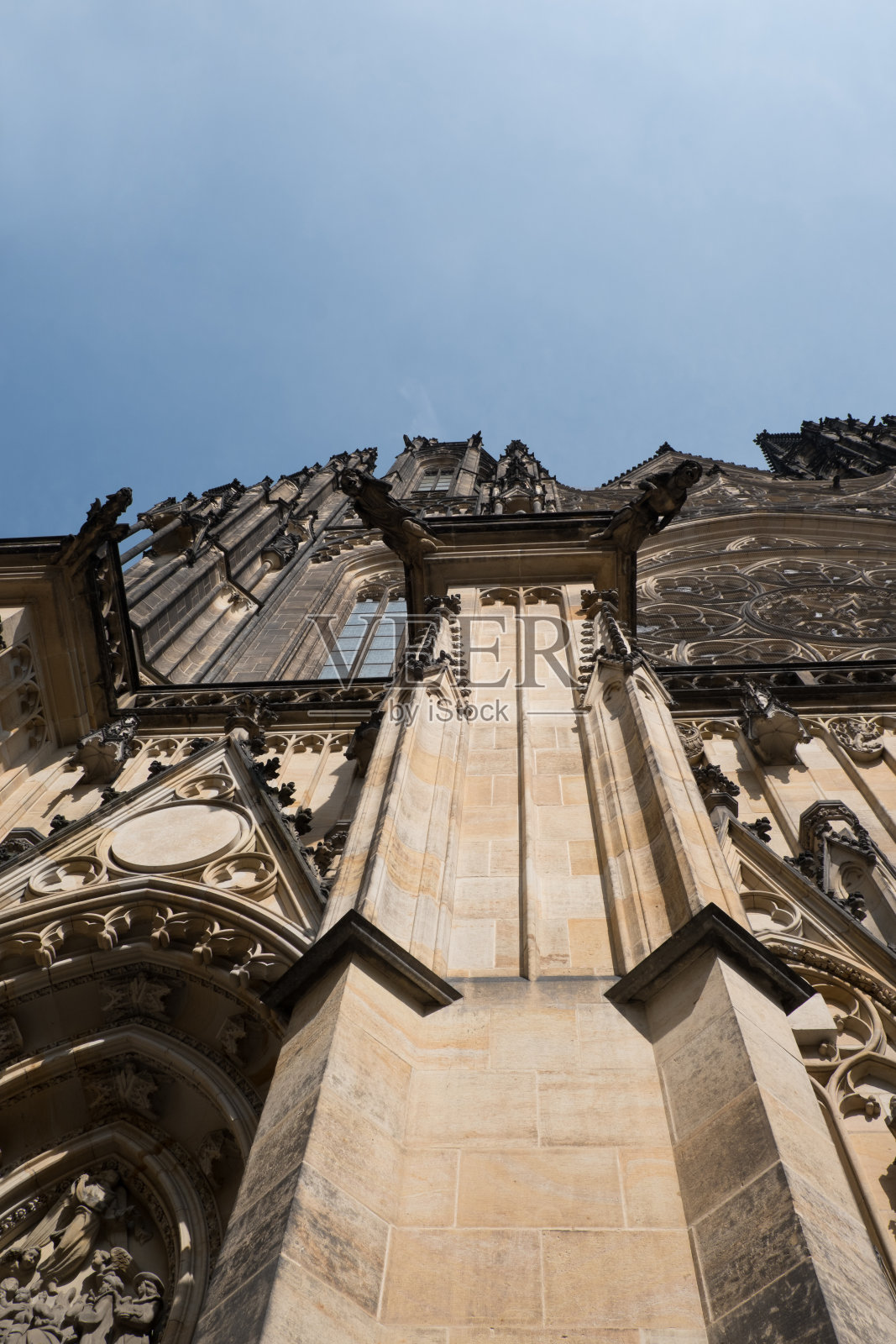 仰望捷克共和国布拉格的圣维塔斯大教堂。布拉格的圣维塔斯大教堂，蓝色的天空，在一个夏日。哥特式建筑的细节。照片摄影图片