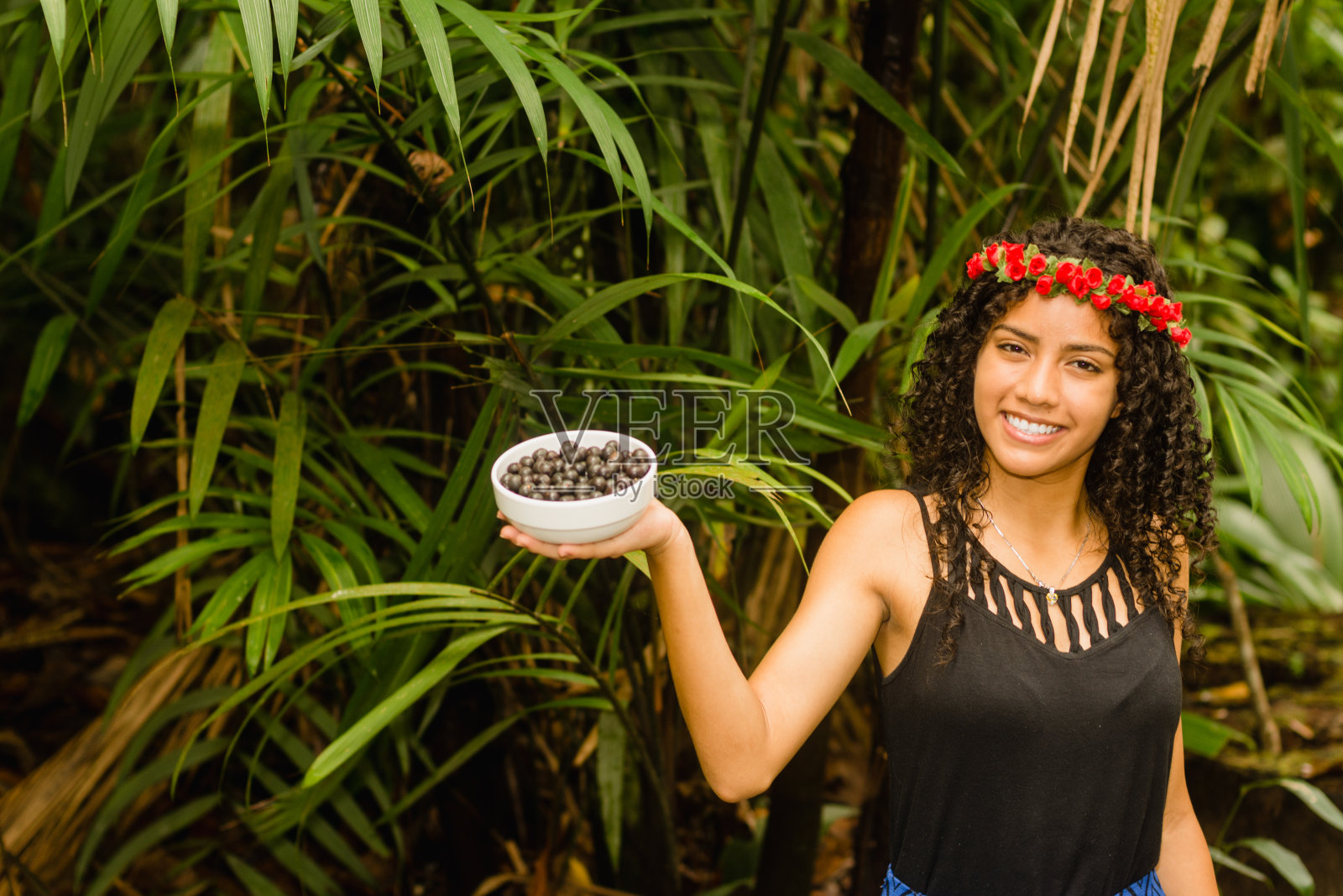 卷发巴西女孩提供阿萨伊浆果碗照片摄影图片