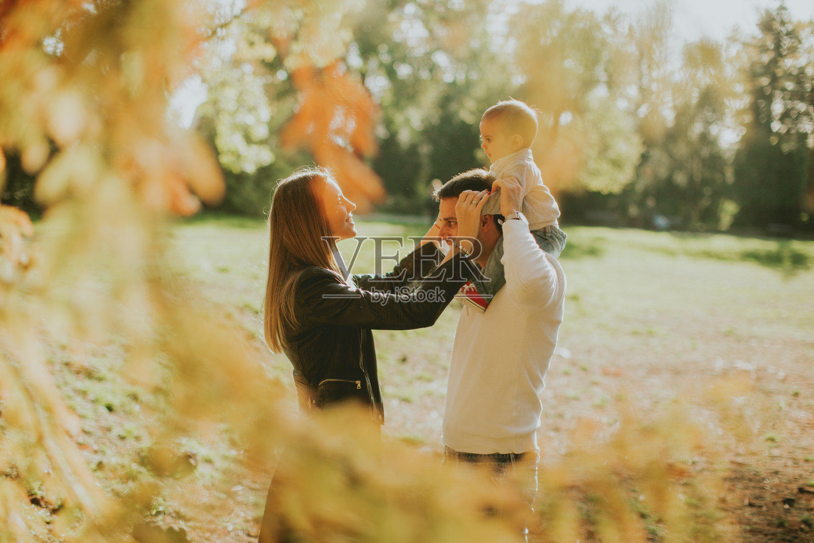 快乐的年轻父母和宝宝在秋天公园照片摄影图片