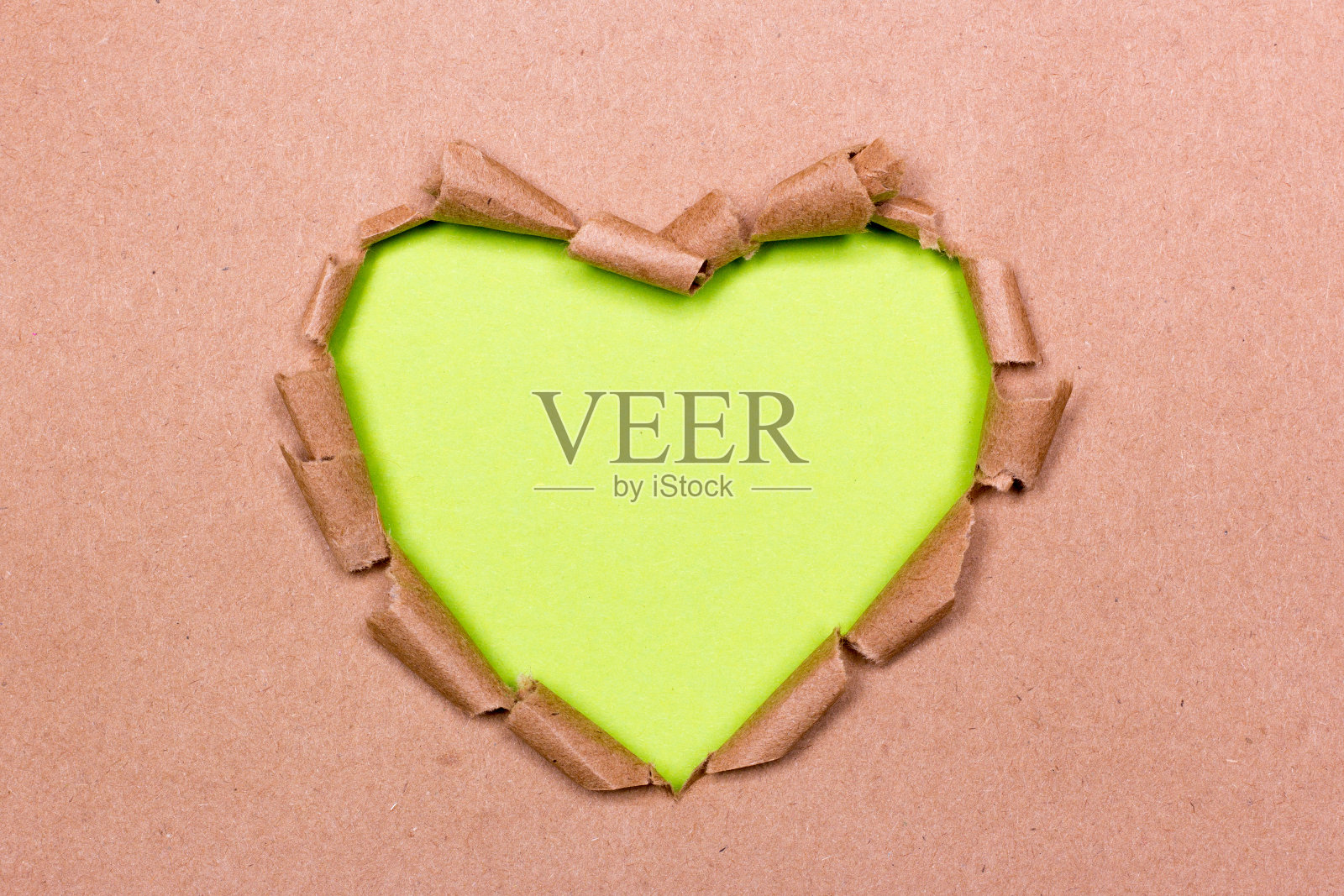 牛皮纸上撕开的绿心洞照片摄影图片