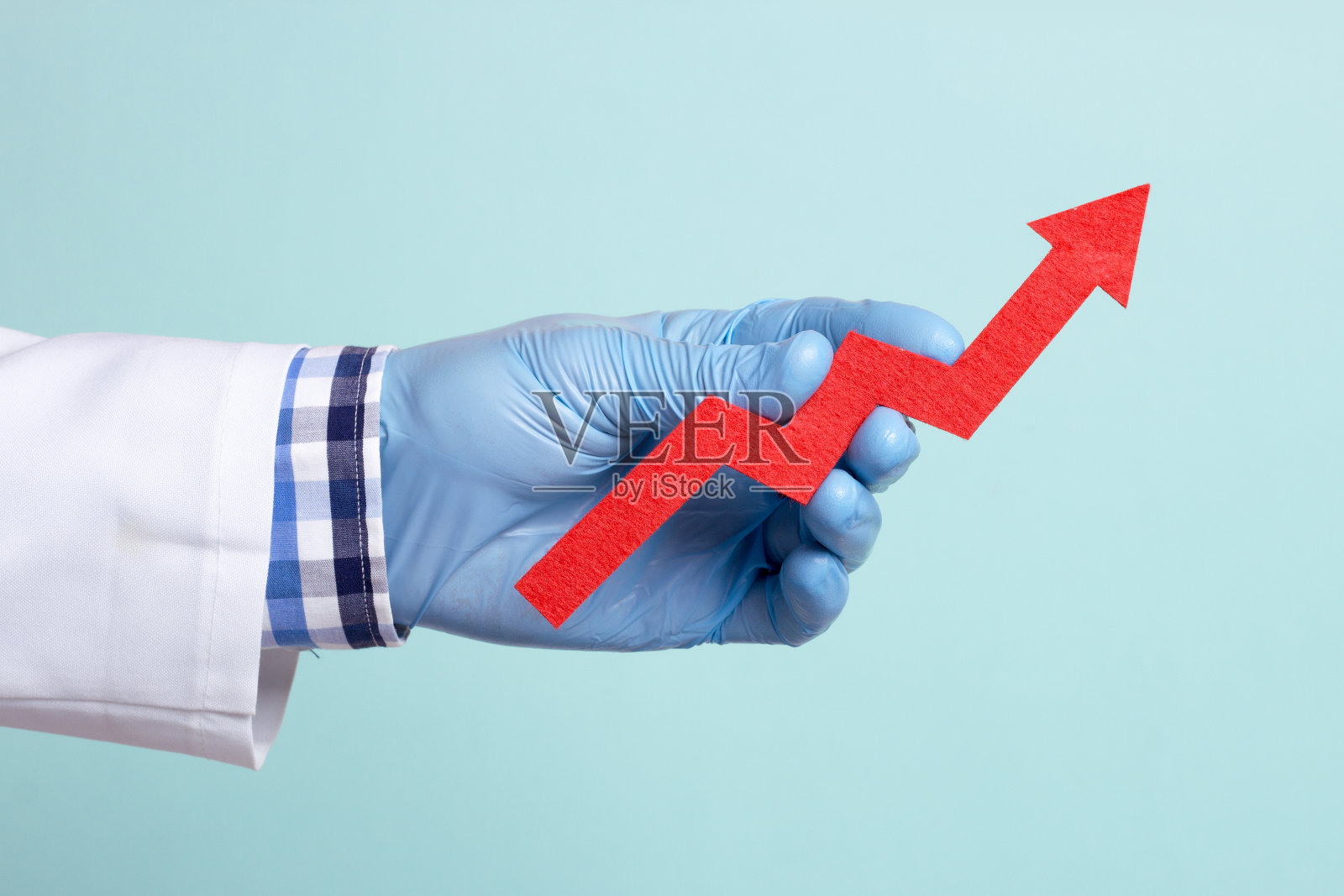 医生手里拿着一支红色的箭，它长大了。指标正在改善，增长是预期的照片摄影图片