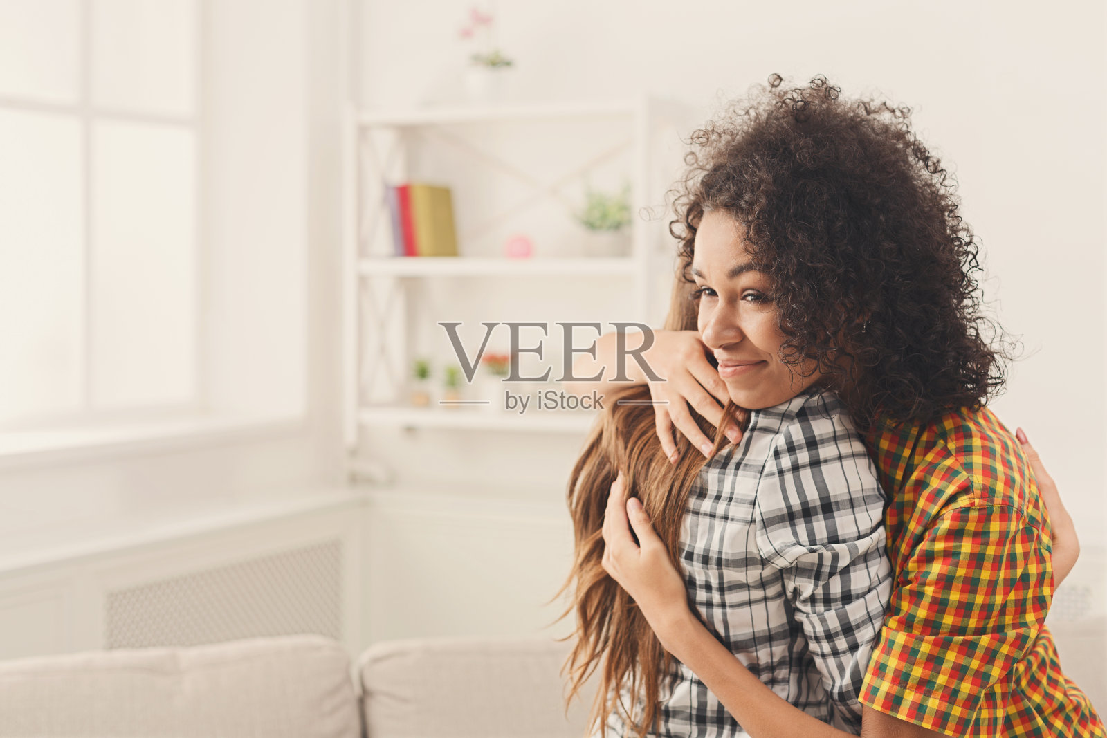 两个女性朋友在家里互相拥抱照片摄影图片