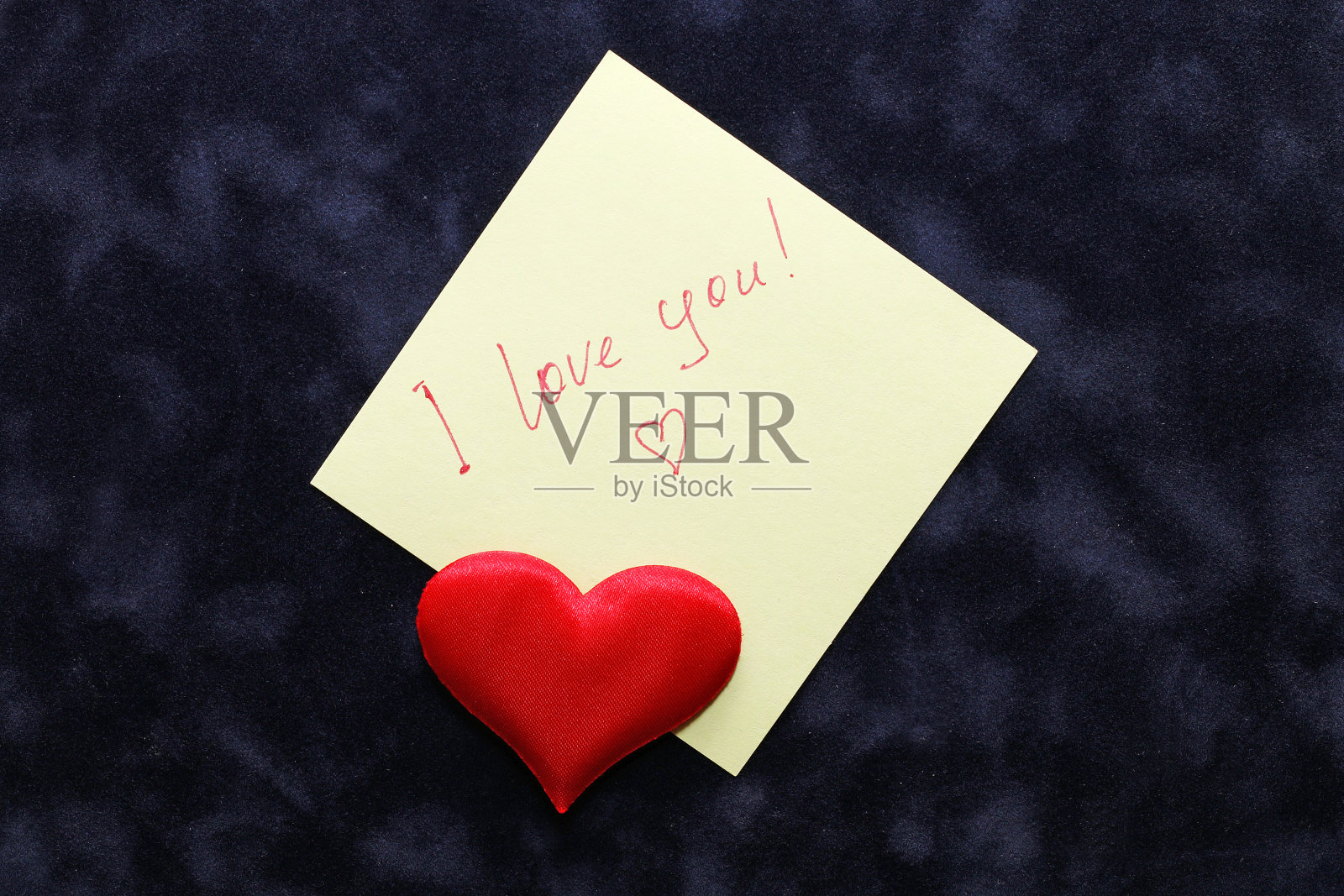 情人节。蓝色天鹅绒上的小纸条和装饰性的心。照片摄影图片