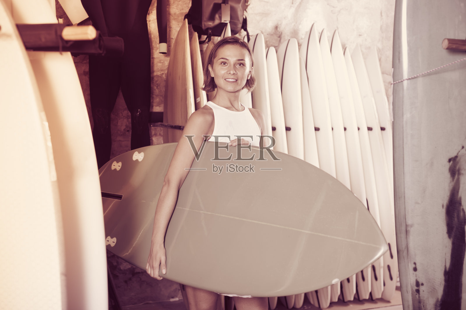 迷人的女人在现代商店选择多彩的冲浪板照片摄影图片