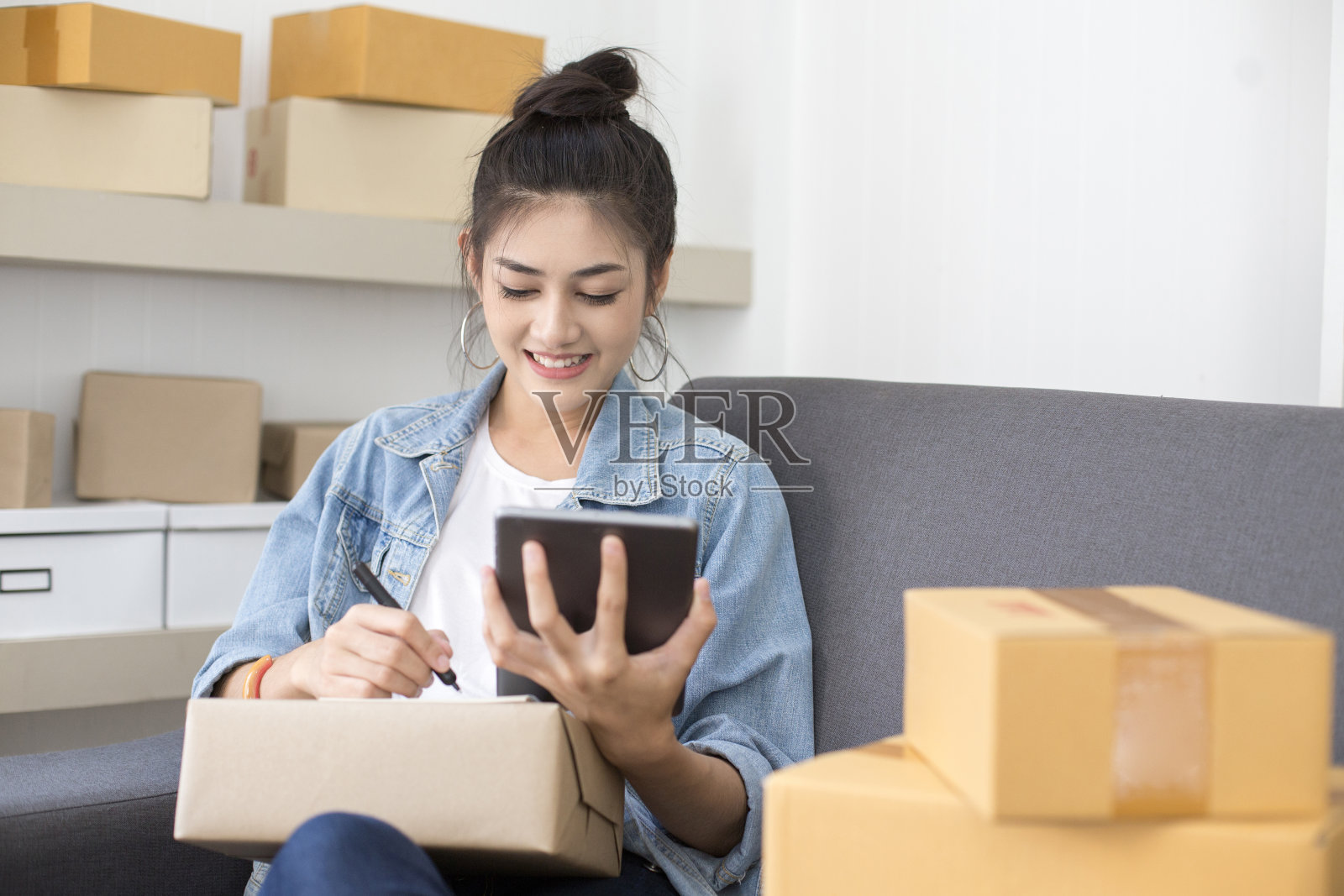 年轻的亚洲女性在家工作，年轻的女性业主开始在线业务，中小企业，交付项目，女性在线业务或中小企业概念。照片摄影图片