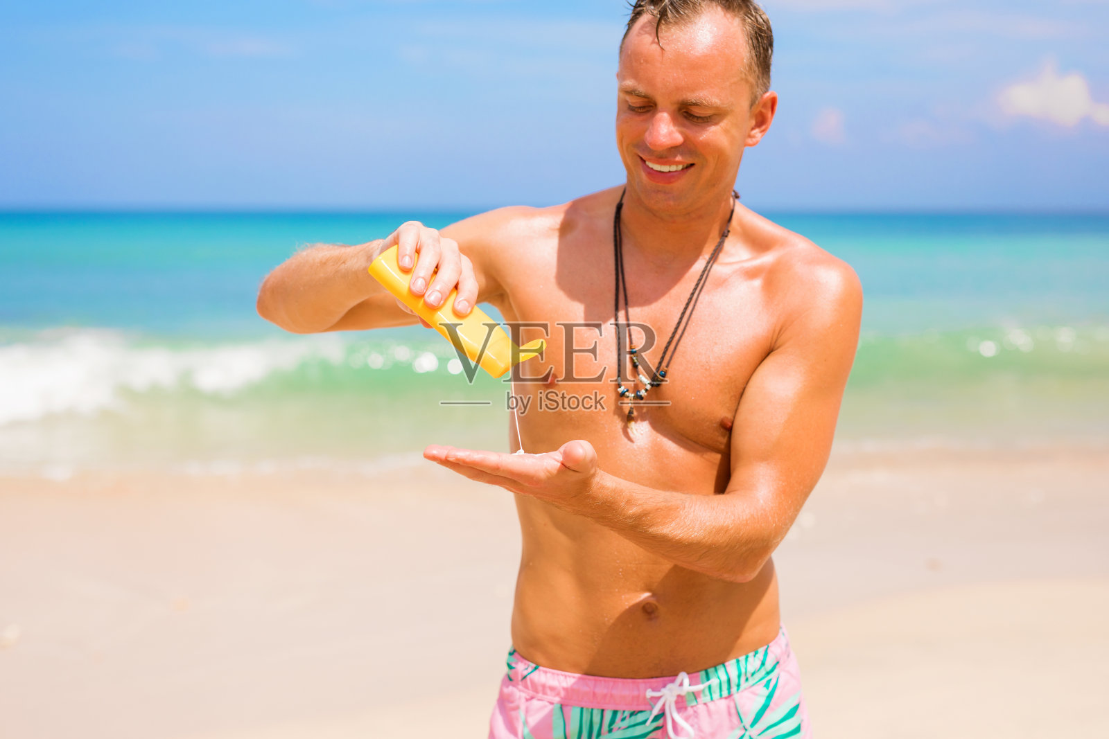 在阳光明媚的日子里，一名男子正在涂防晒霜照片摄影图片