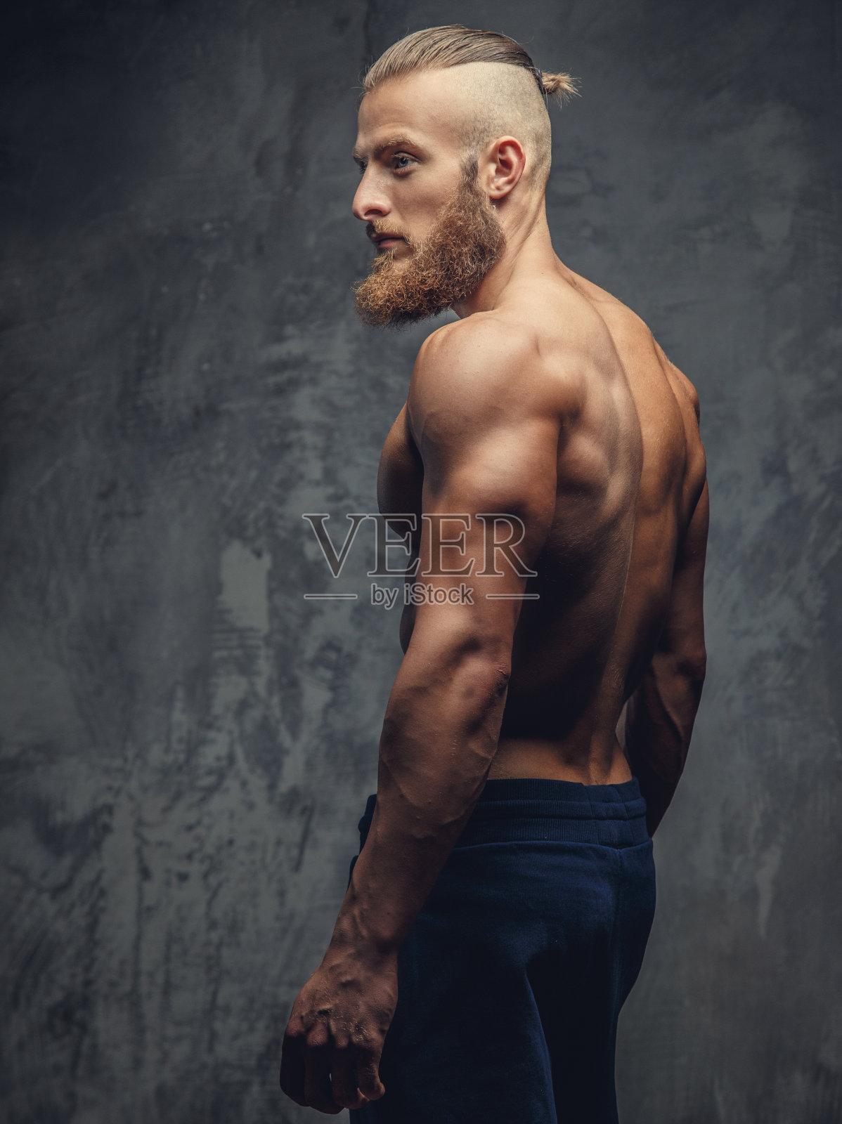 留着胡子的肌肉男在工作室摆姿势。照片摄影图片