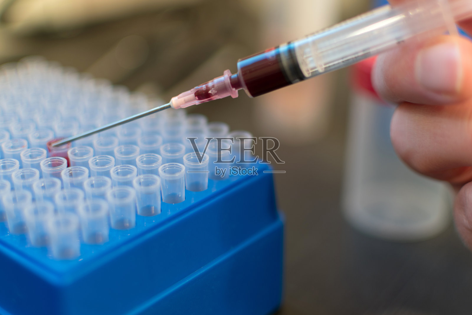 在科学实验室用注射器注射血液照片摄影图片
