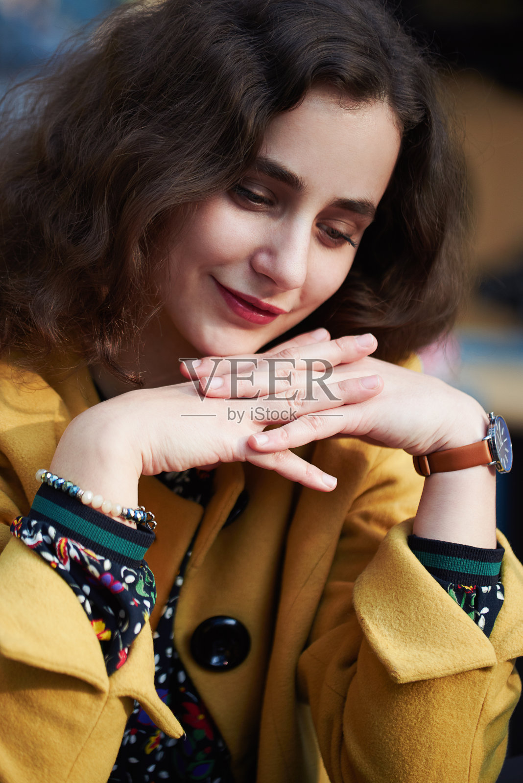 年轻女子坐在室内，在白天看着可爱的脸和小微笑照片摄影图片