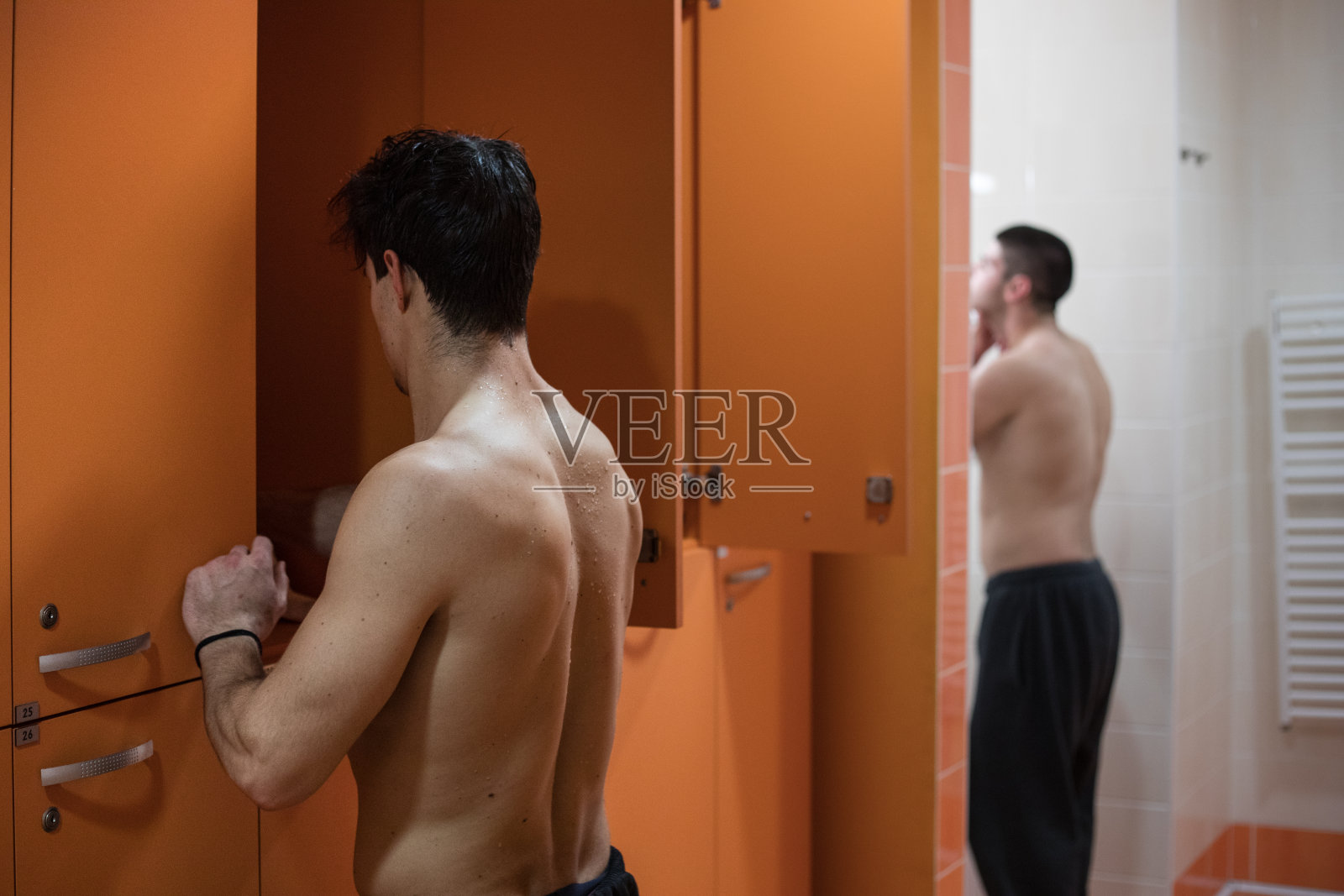 年轻肌肉男在更衣室训练后在健身房照片摄影图片