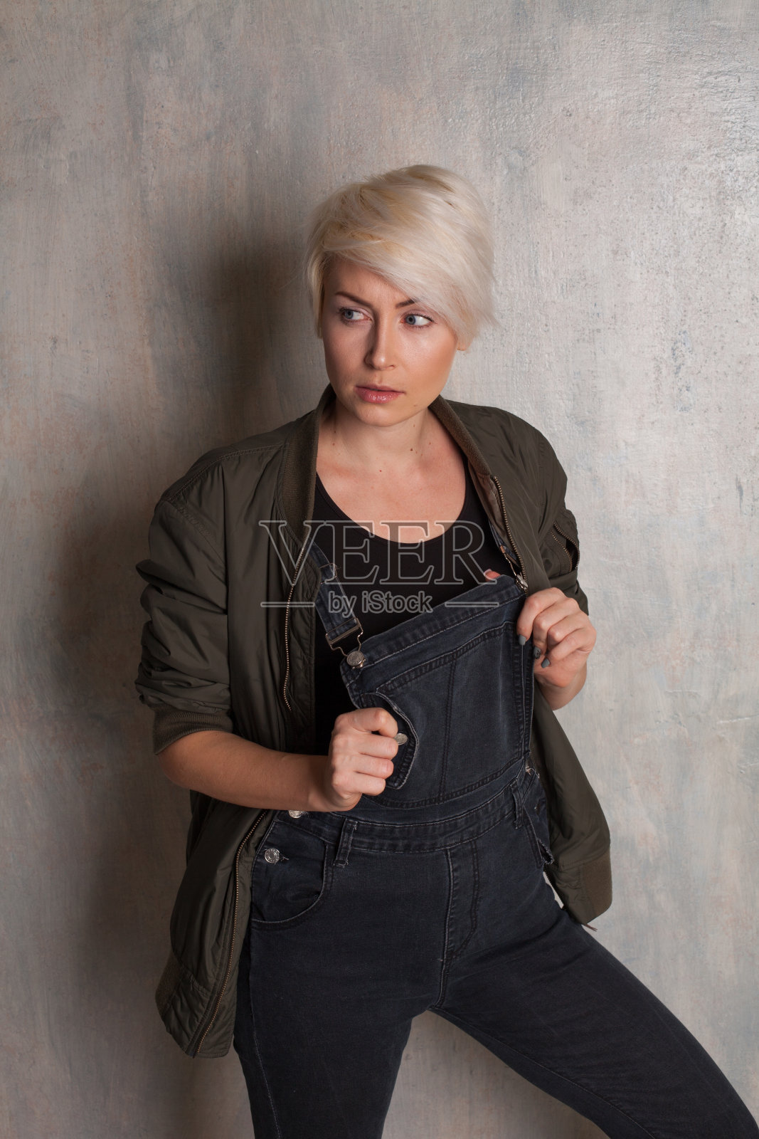 来自旧墙的非正式金发女孩照片摄影图片