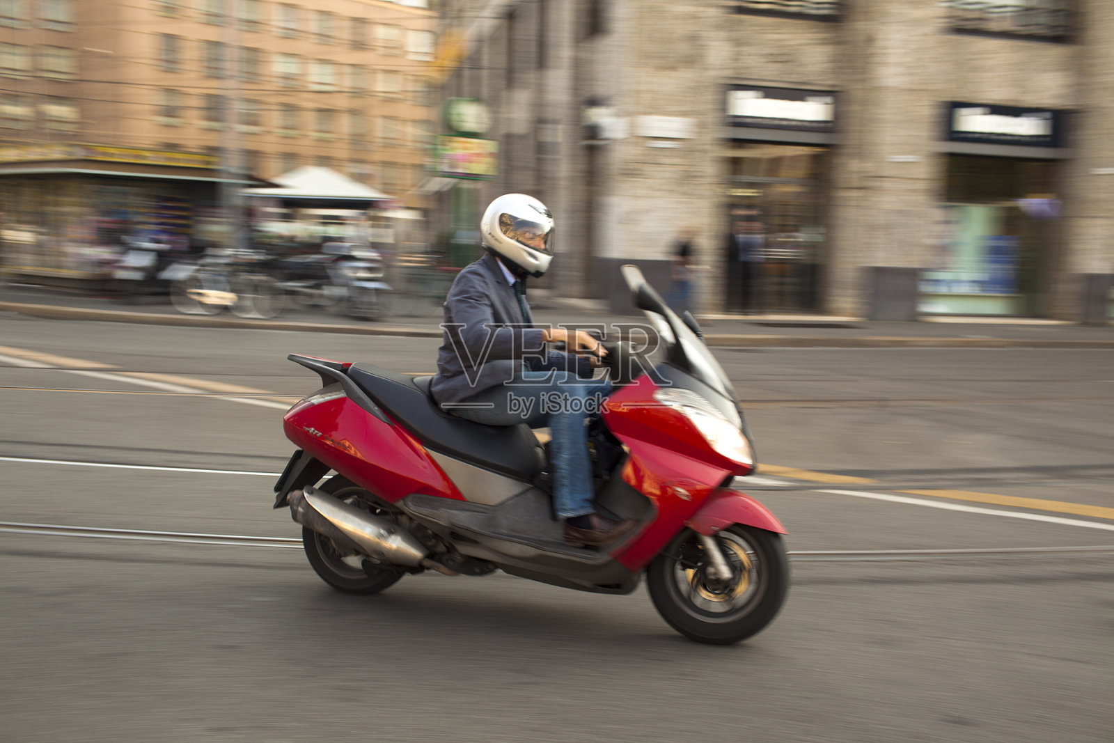 在米兰，一个骑着红色摩托车的男人照片摄影图片