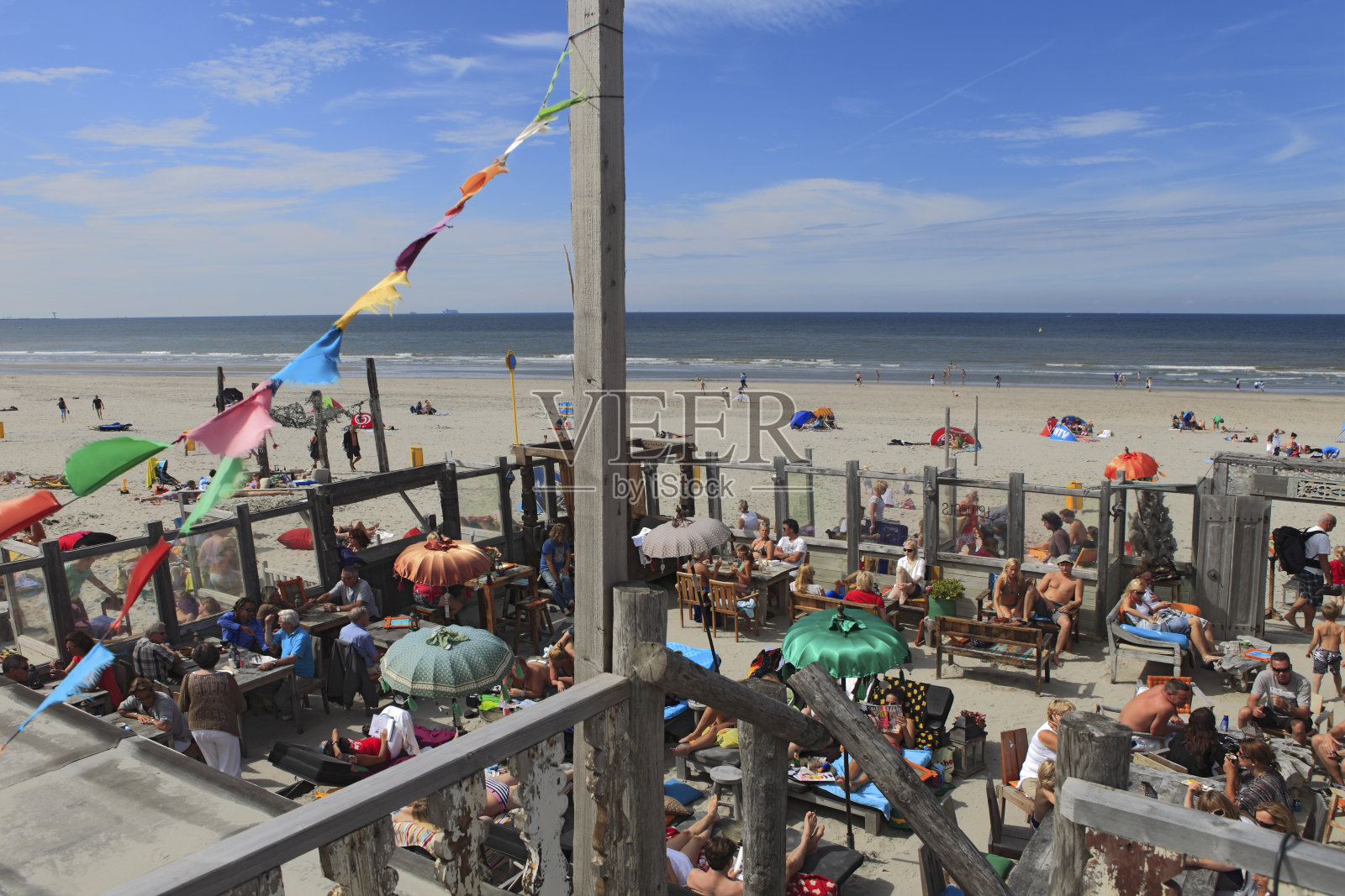 人们在海滩酒吧的露台上享受照片摄影图片