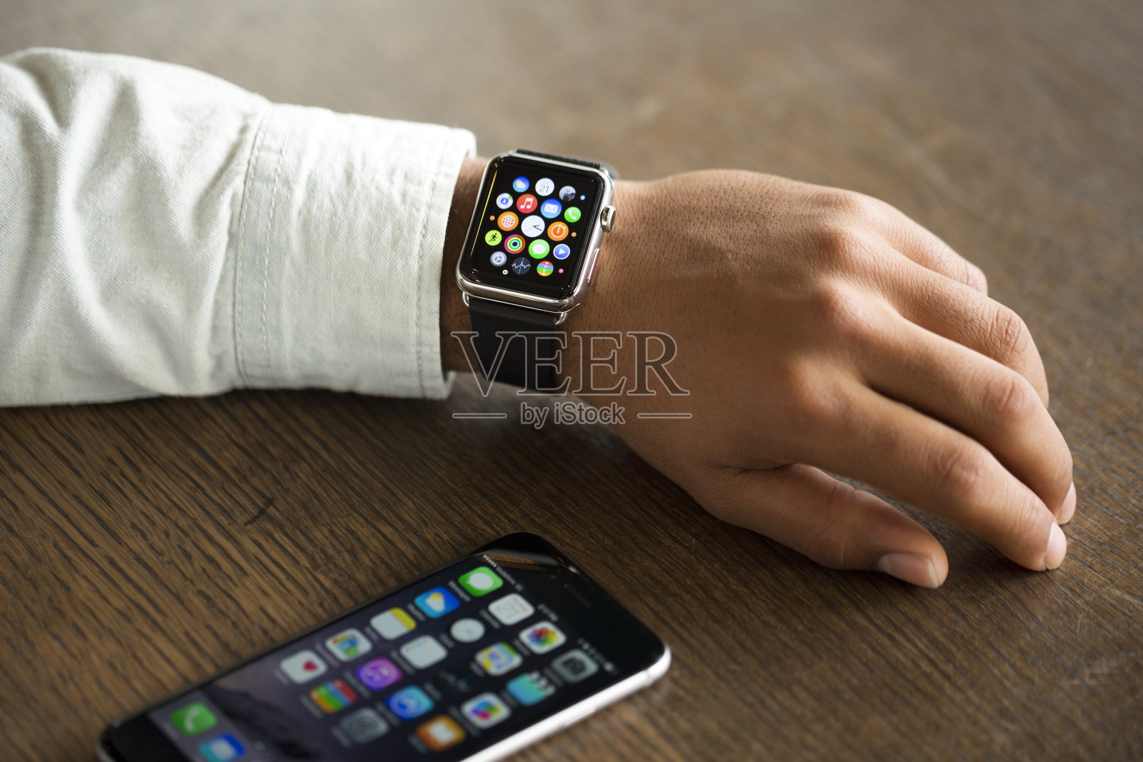 有人用iPhone检查他的苹果手表照片摄影图片