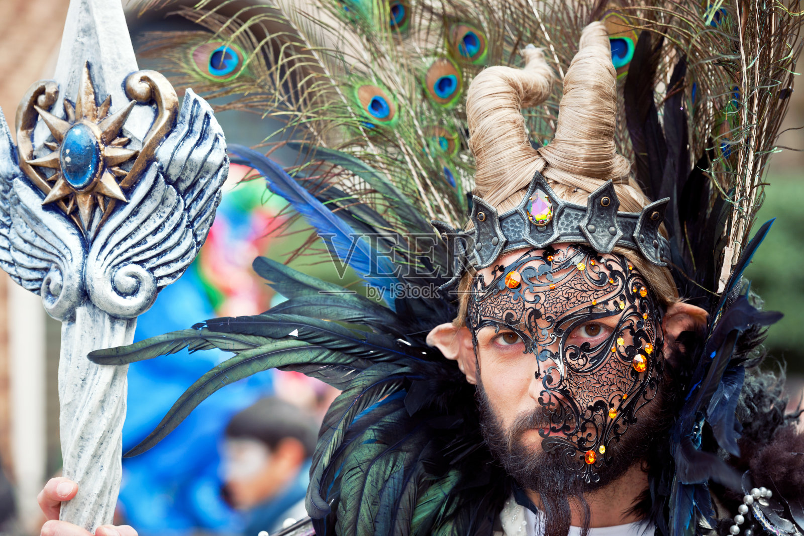 圣乔治威尼斯狂欢节上戴着羽毛面具的男子照片摄影图片