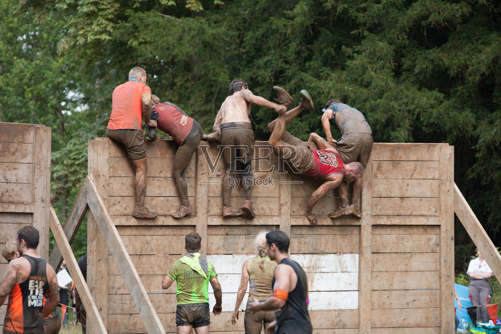 一群人互相帮助对付木栅栏照片摄影图片