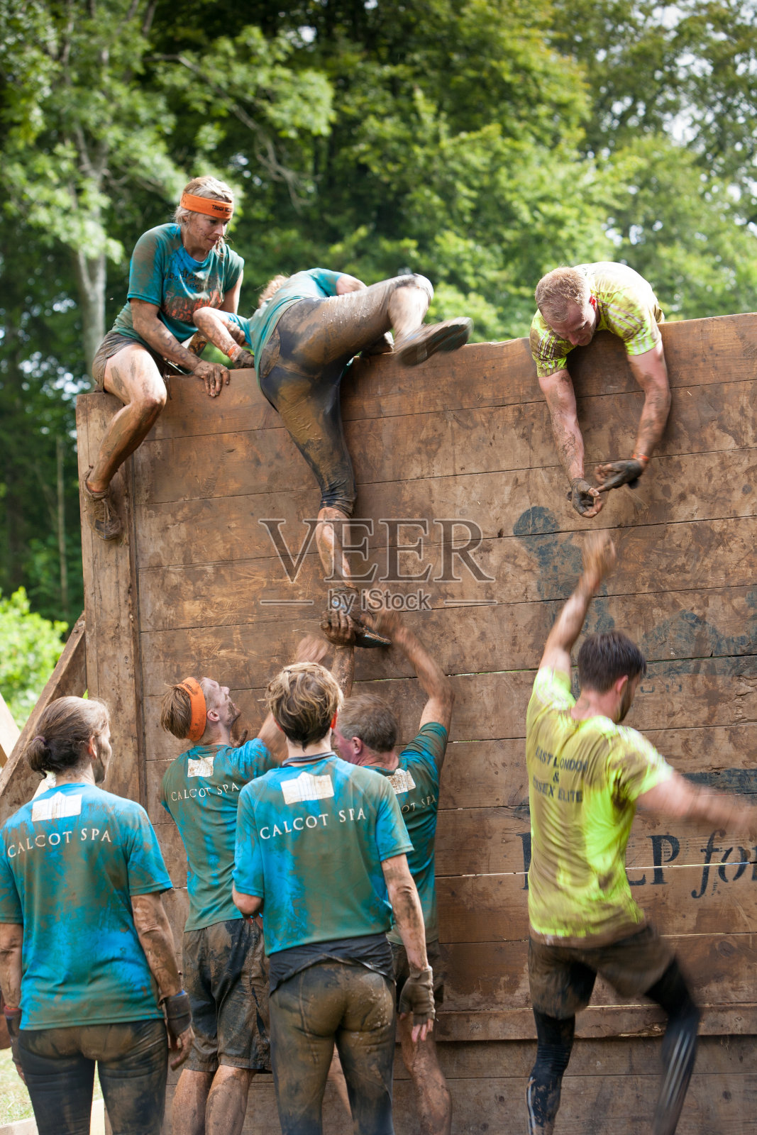 一群人互相帮助解决一个木制障碍照片摄影图片
