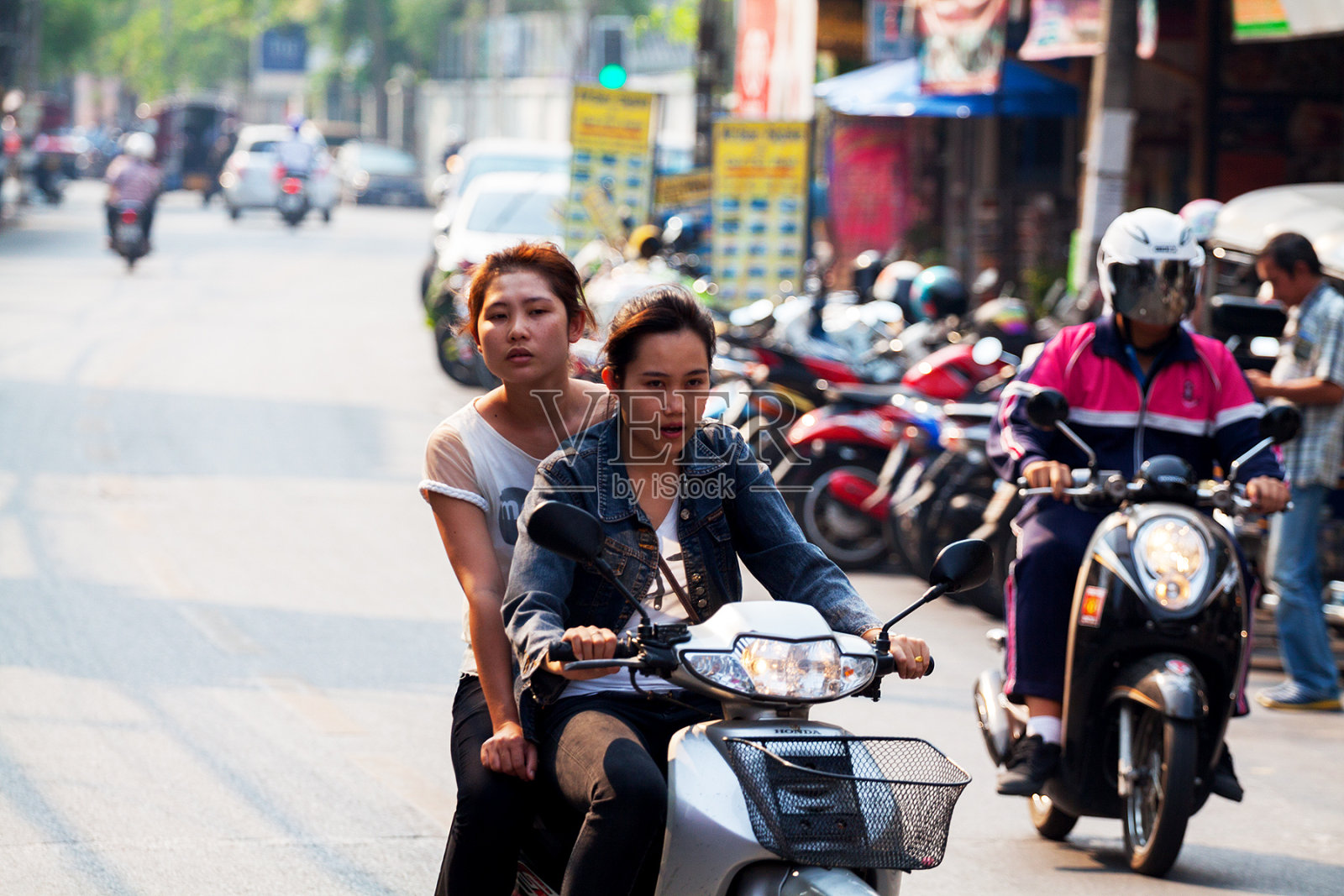 两个年轻的泰国女孩骑摩托车照片摄影图片