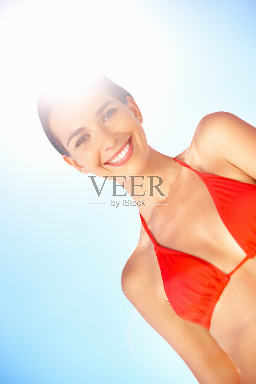 快乐的年轻女子穿着红色比基尼对抗天空照片摄影图片