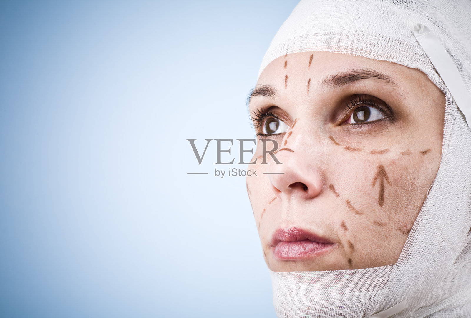 年轻女子的头部裹着绷带，脸上有标记照片摄影图片