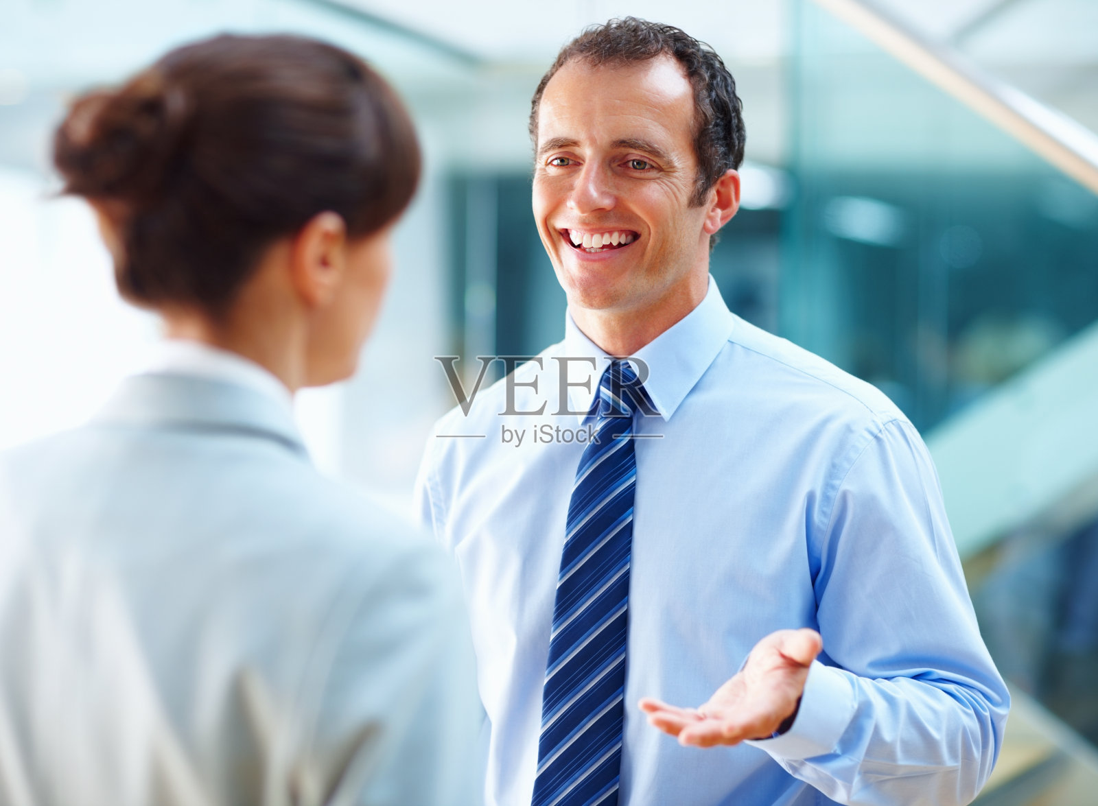 微笑的商人与他的同事讨论照片摄影图片