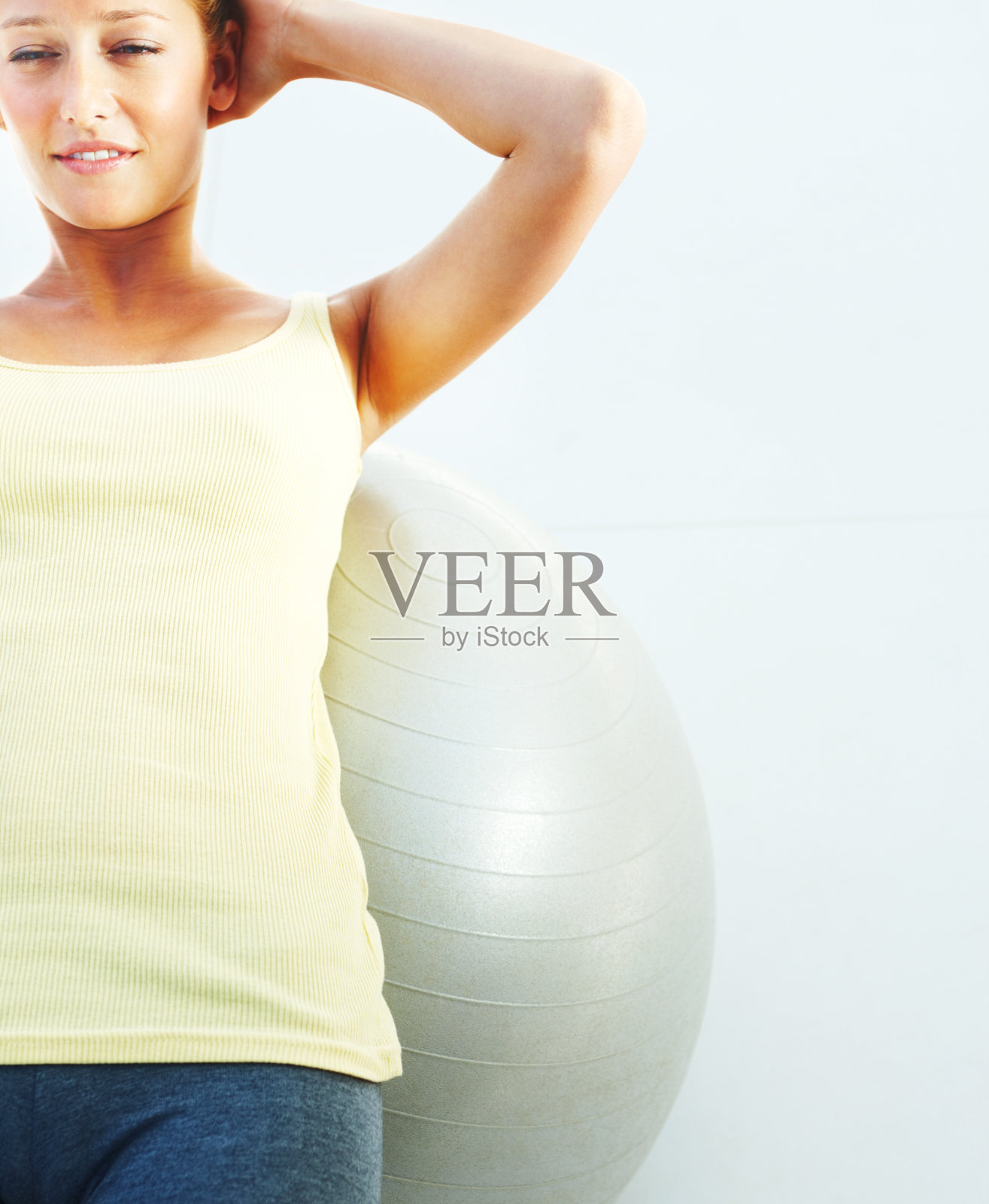 小女孩双手放在脑后，躺在健身球上照片摄影图片