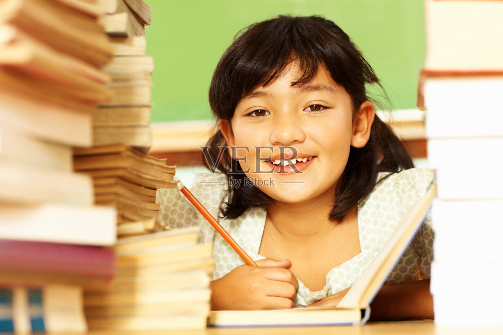 快乐的女孩拿着一堆书看书照片摄影图片