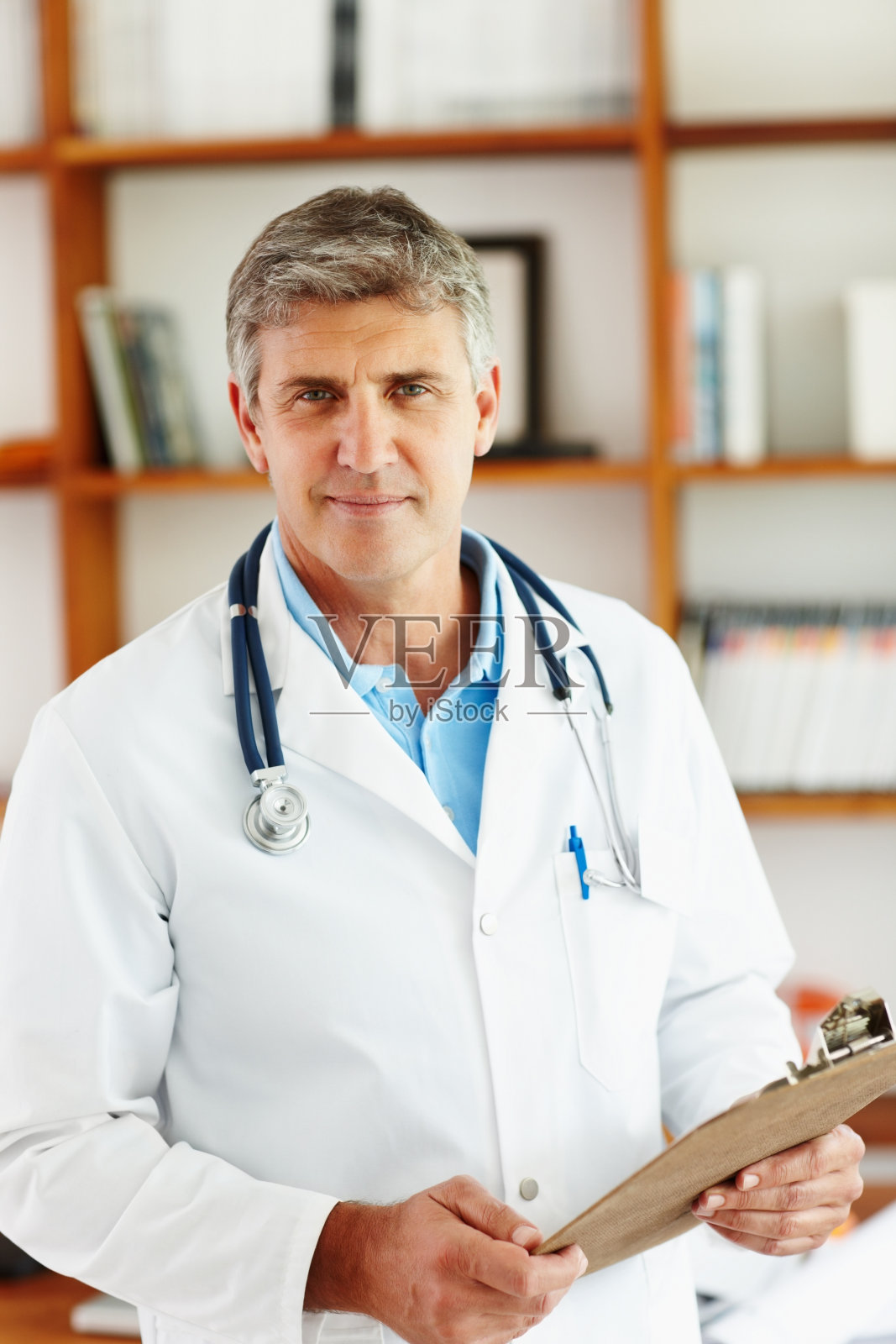 诊所里拿着病历的男医生照片摄影图片