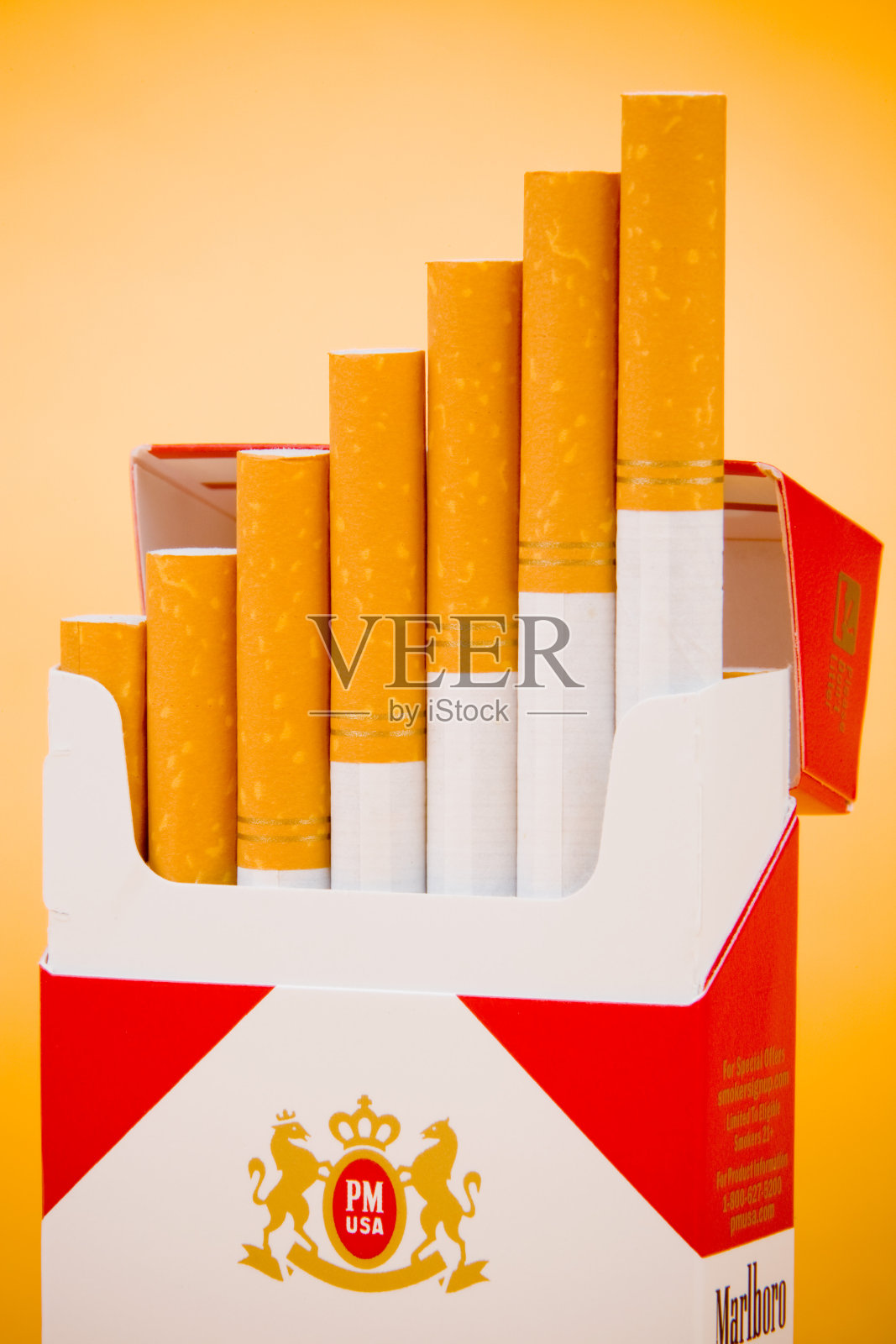 万宝路香烟在一个开着的橙色背景的盒子里照片摄影图片