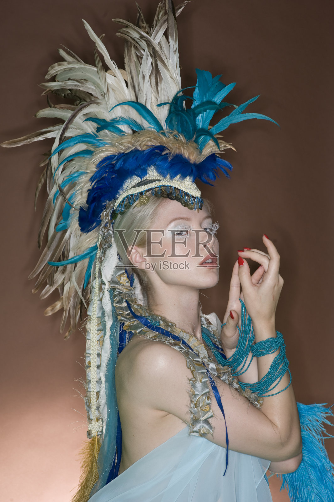 戴着羽毛头饰的年轻女子照片摄影图片