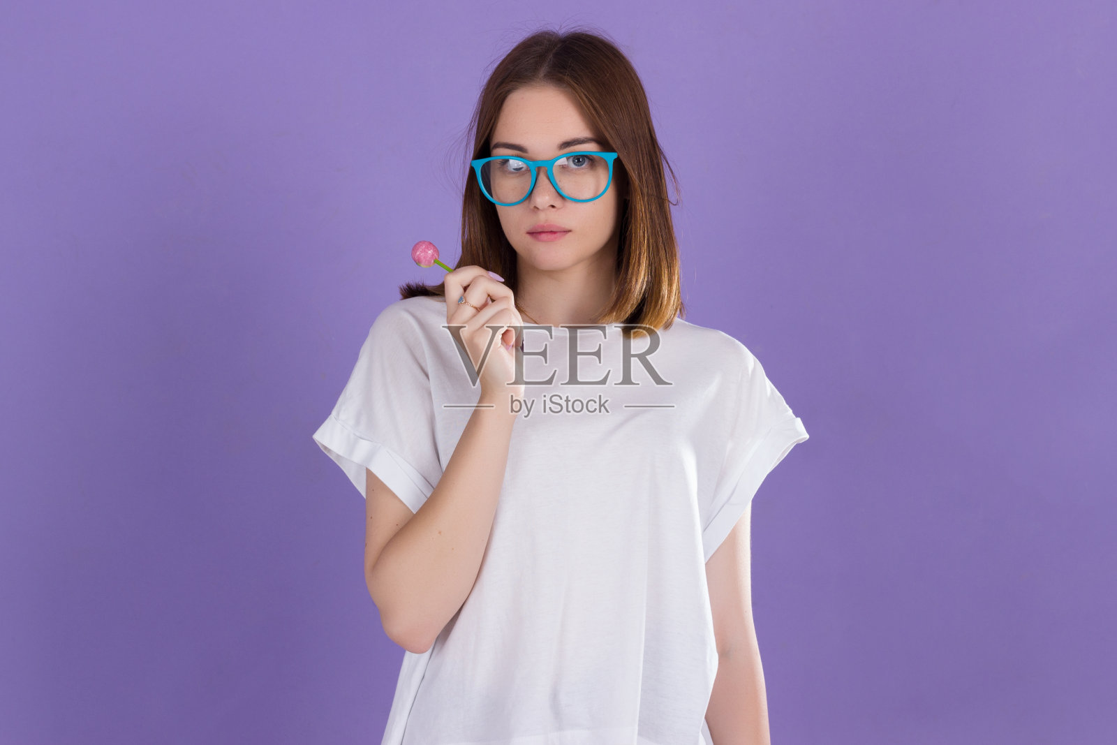 年轻漂亮的女孩拿着棒棒糖，快乐可爱照片摄影图片