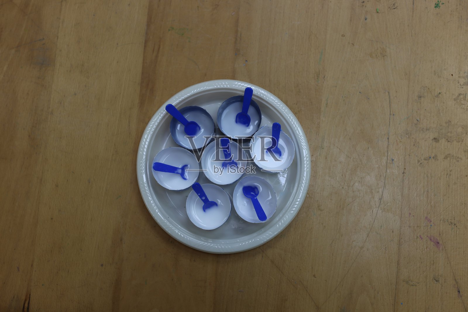 创意工作室用一次性盘子、7杯塑料胶水和小勺子照片摄影图片