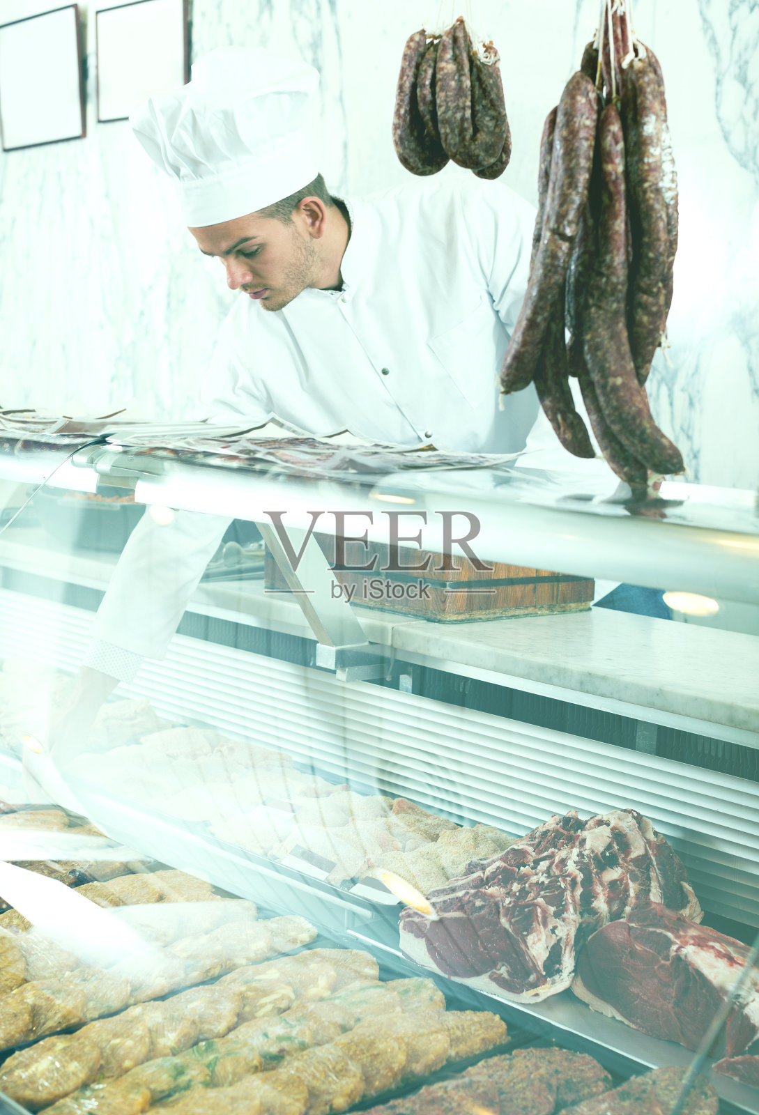 穿着工作服拿生肉的小贩照片摄影图片