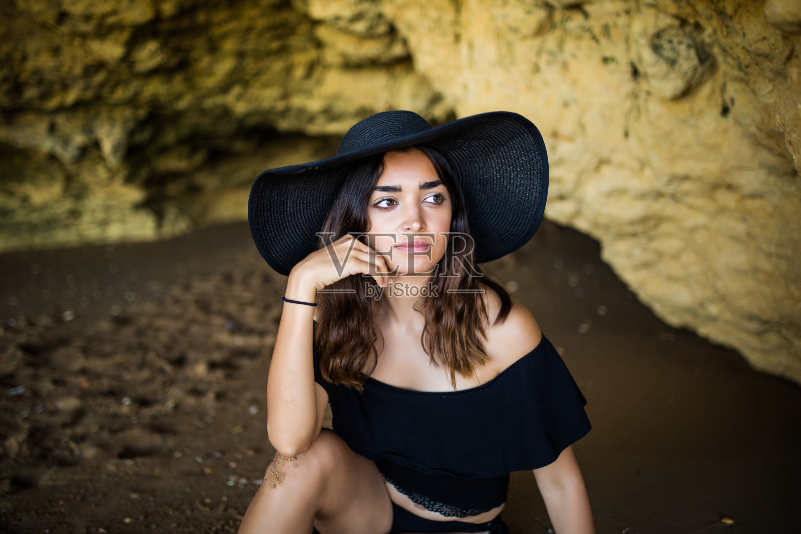 快乐美丽的拉丁女人坐在附近的岩石海滩在暑假时间照片摄影图片