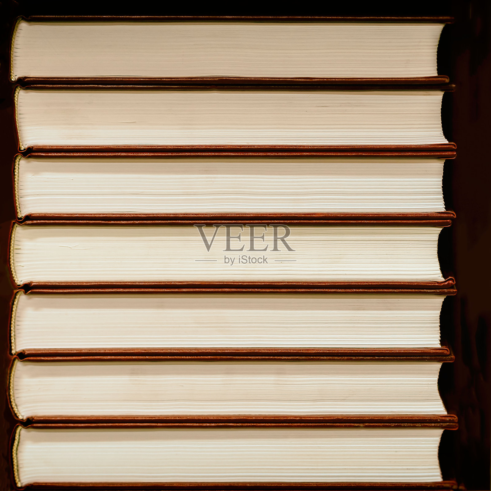 一堆精装书，紧闭着，背景是黑色的照片摄影图片