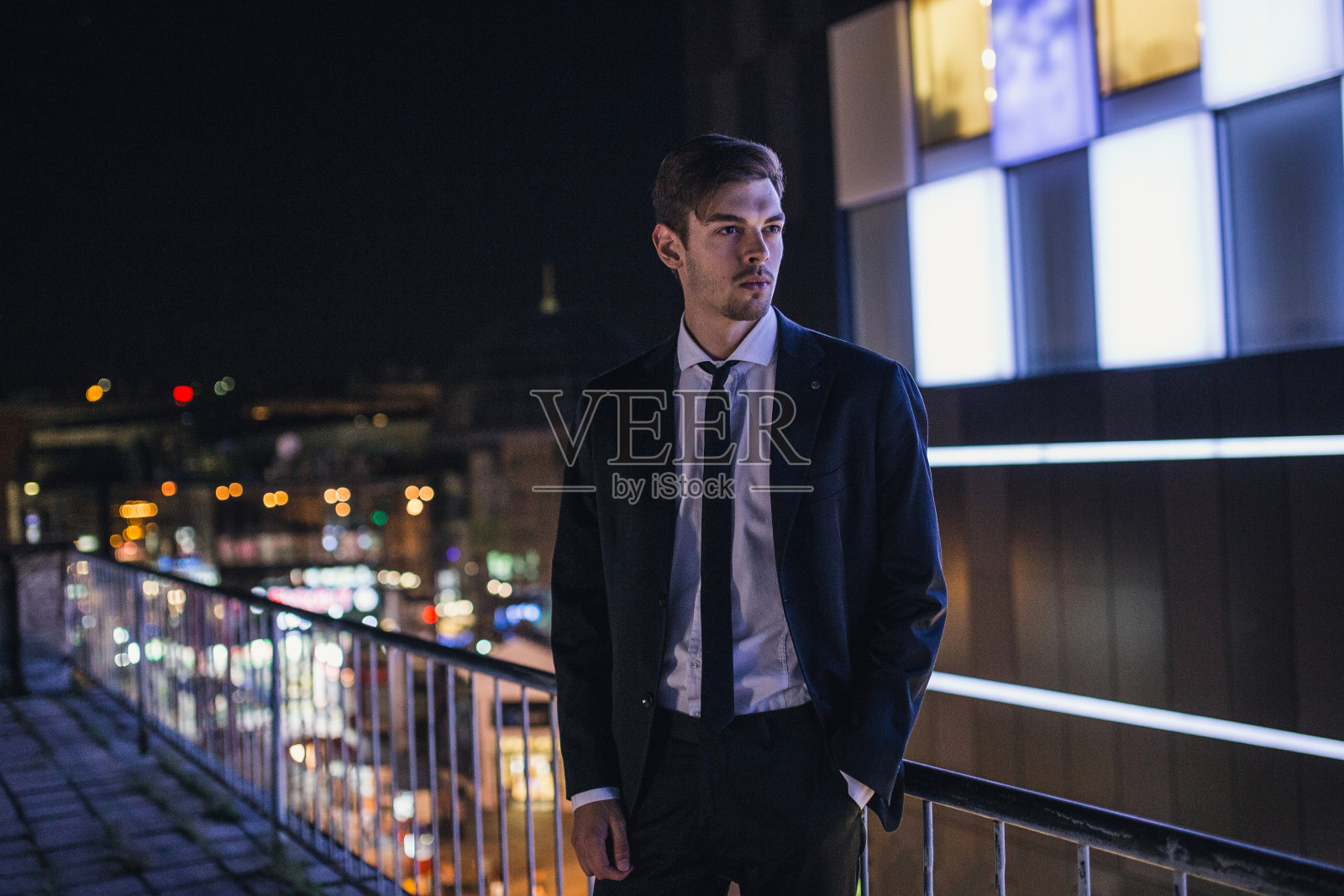 晚上站在楼顶的商人照片摄影图片