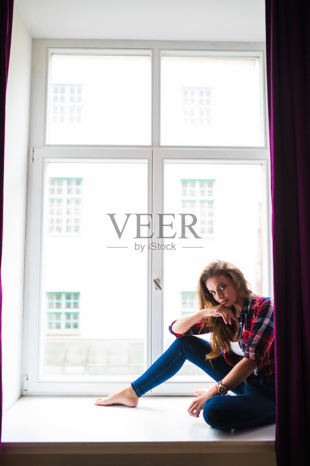 坐在窗台上看窗外的漂亮年轻女子照片摄影图片