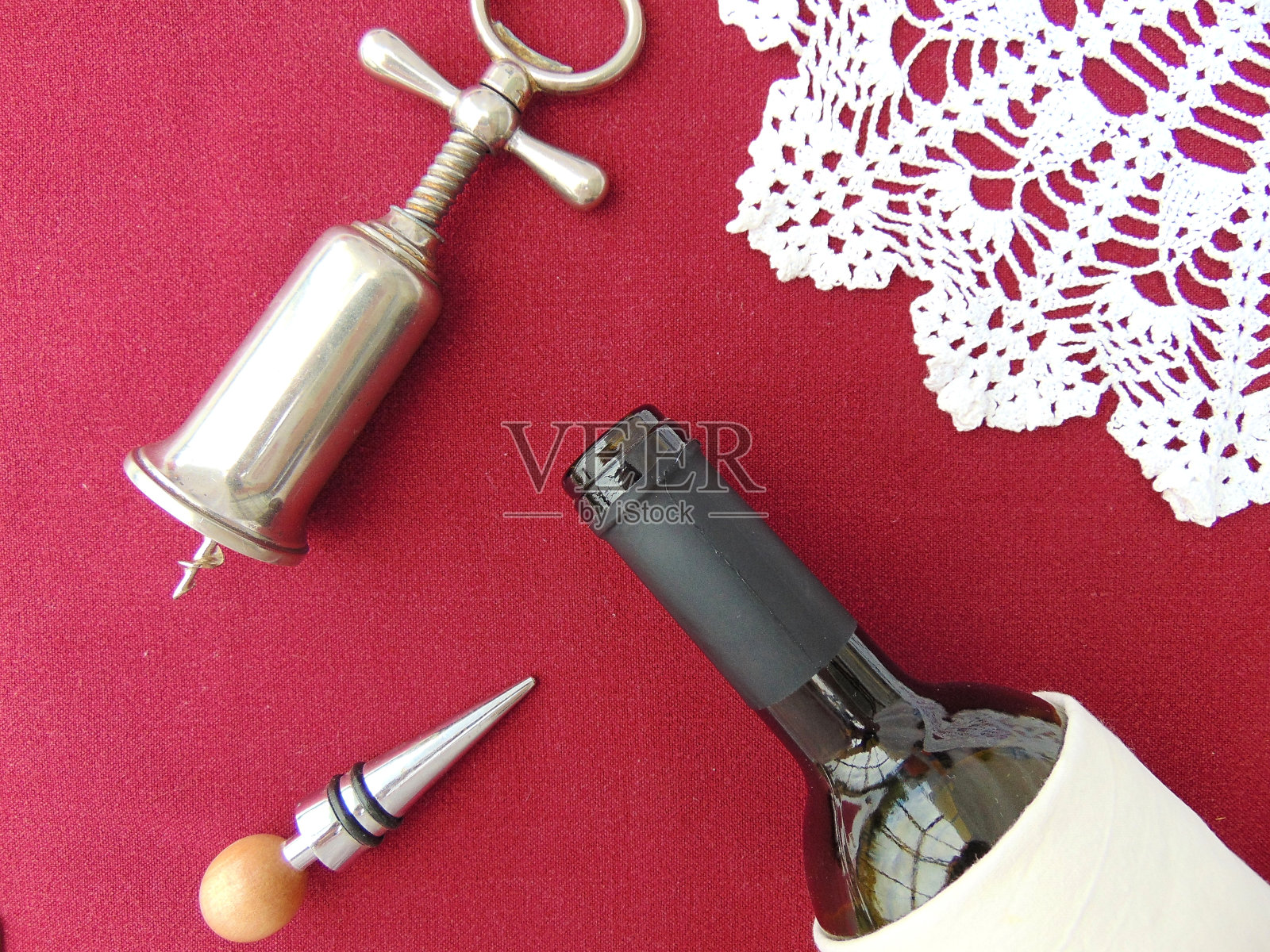 波尔多红色背景上的红酒瓶和开瓶器照片摄影图片