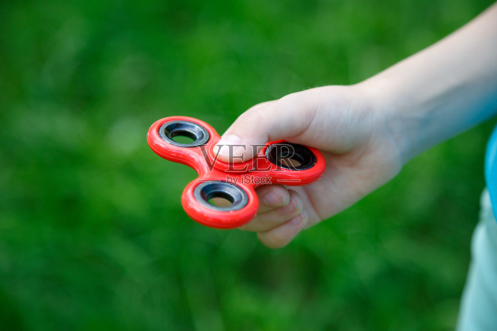 特写红色指尖陀螺在手。受欢迎的微调器工具照片摄影图片