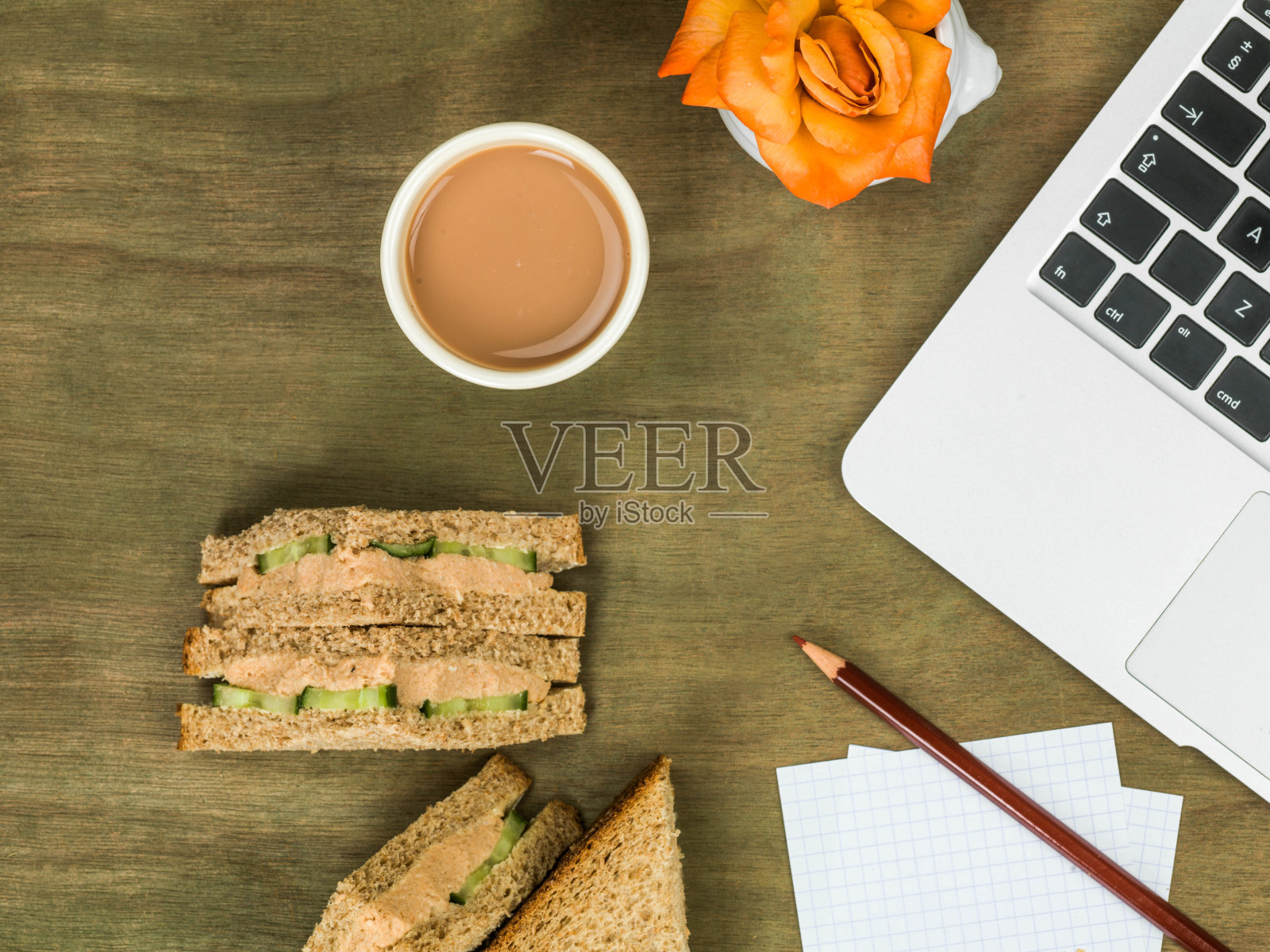 鲑鱼黄瓜黑面包三明治，一杯茶和一台笔记本电脑照片摄影图片