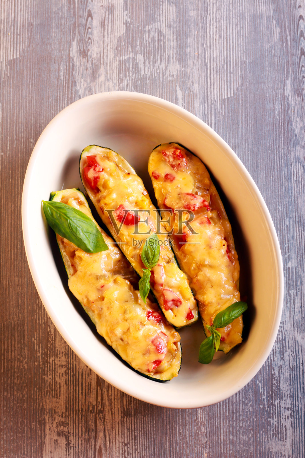 塞满了蔬菜和融化的奶酪的西葫芦照片摄影图片