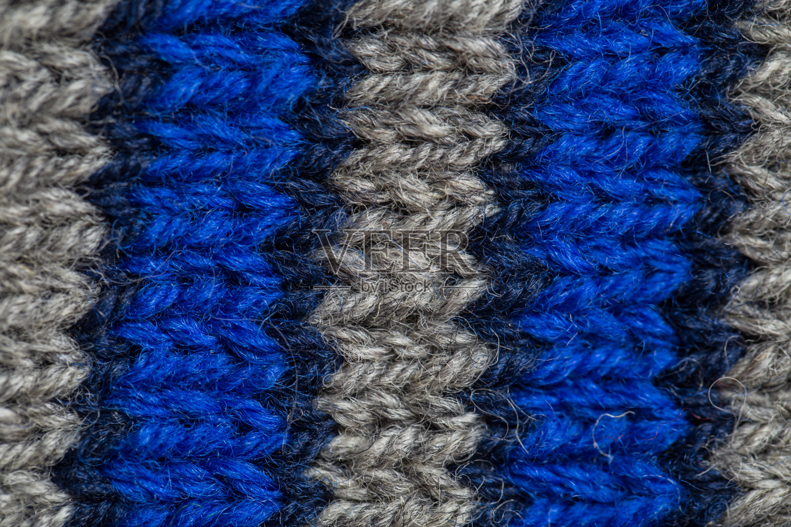 一个漂亮的特写手编织温暖和柔软的羊毛图案。天然羊毛的软袜子或围巾。照片摄影图片