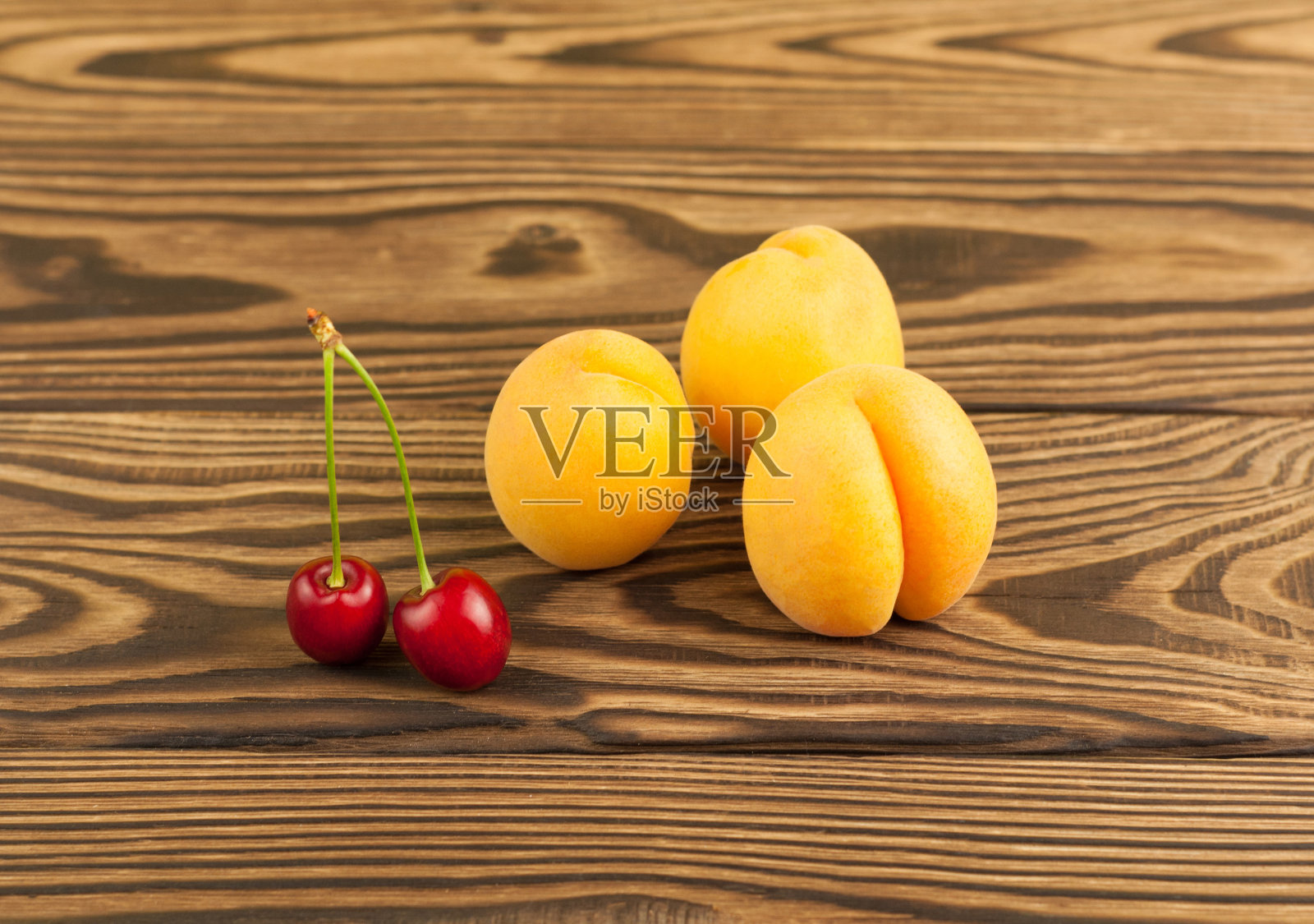 成熟的新鲜杏和樱桃在旧木背景照片摄影图片