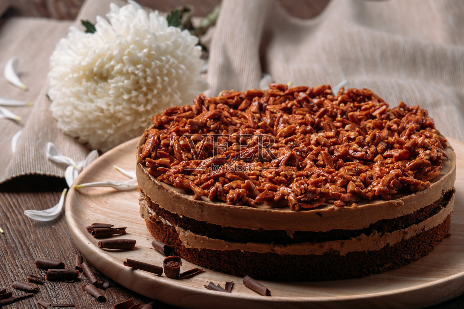 木盘杏仁蛋糕与白色花朵照片摄影图片