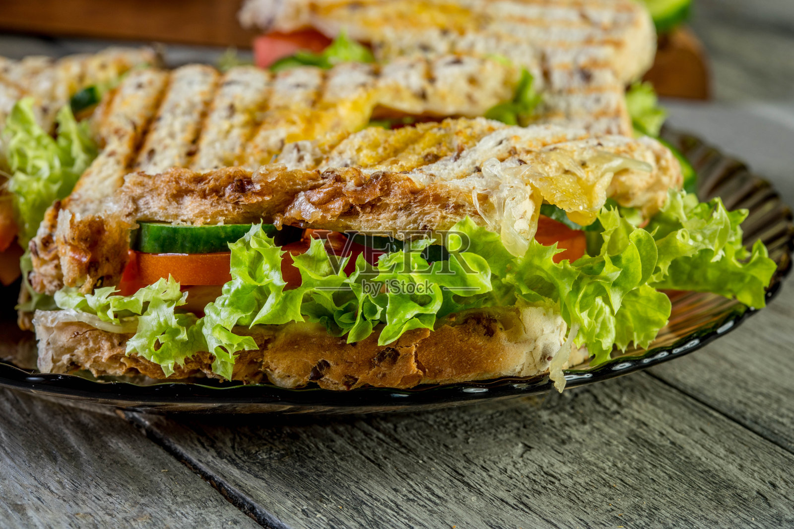 夹有火腿、番茄和生菜的帕尼尼三明治。照片摄影图片