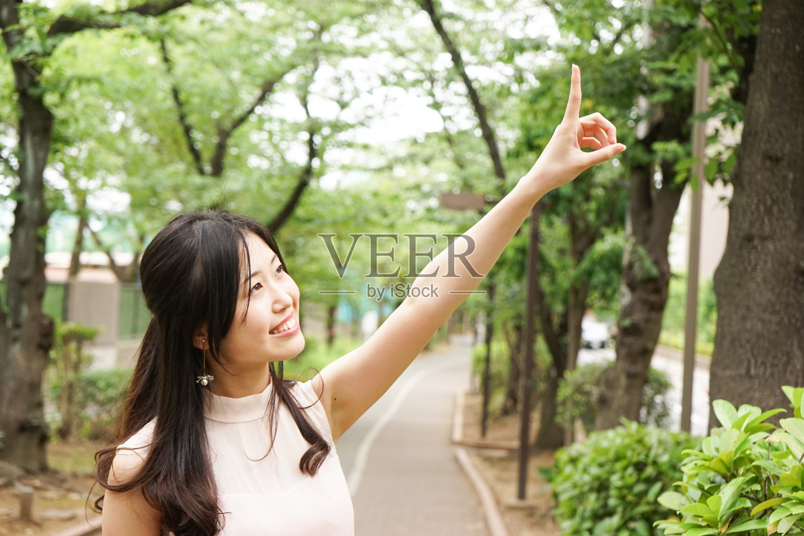 年轻女子微笑着指着什么东西照片摄影图片